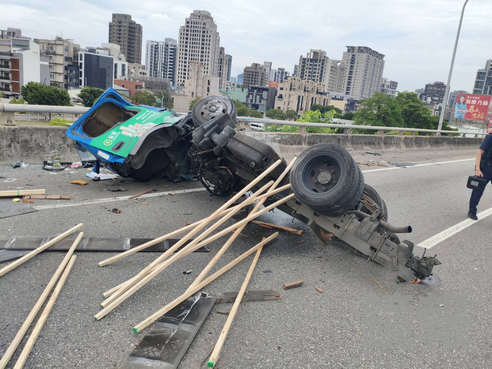 小貨車遭撞翻覆,後斗碎裂散落僅剩底盤,載運的木條與捆繩散落在路面。民眾提供