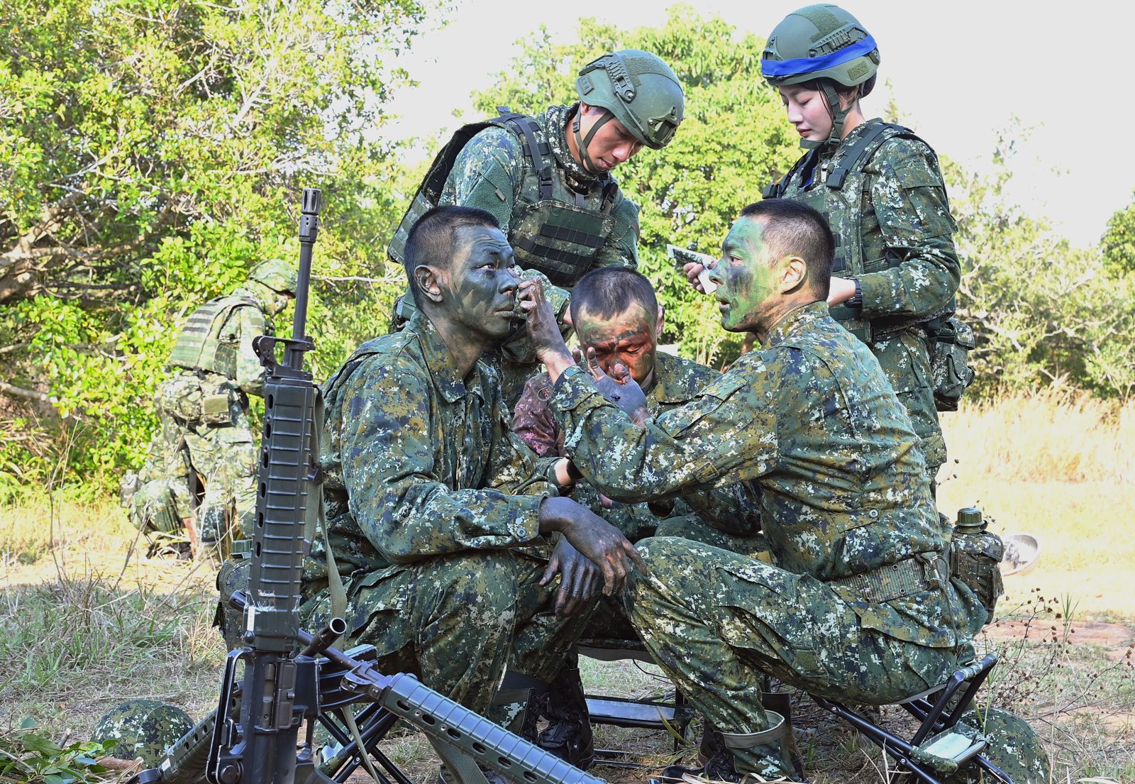 星兵們進行偽裝，互相幫忙塗抹顏料。台視提供