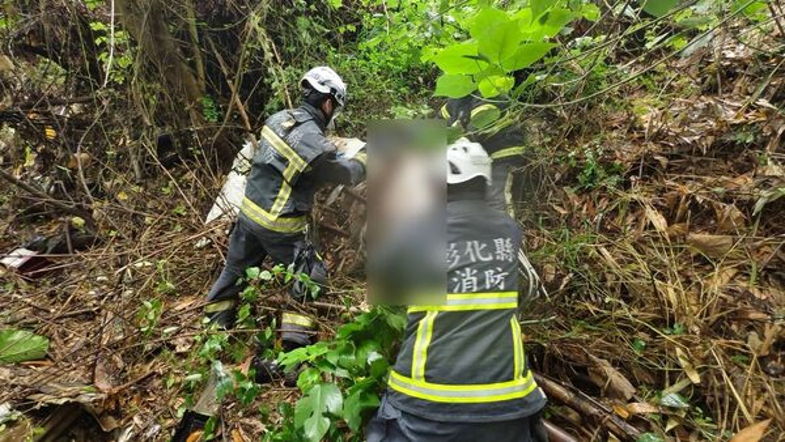 警消將遺體移出荔枝園，交由鑑識小組調查採證。民眾提供