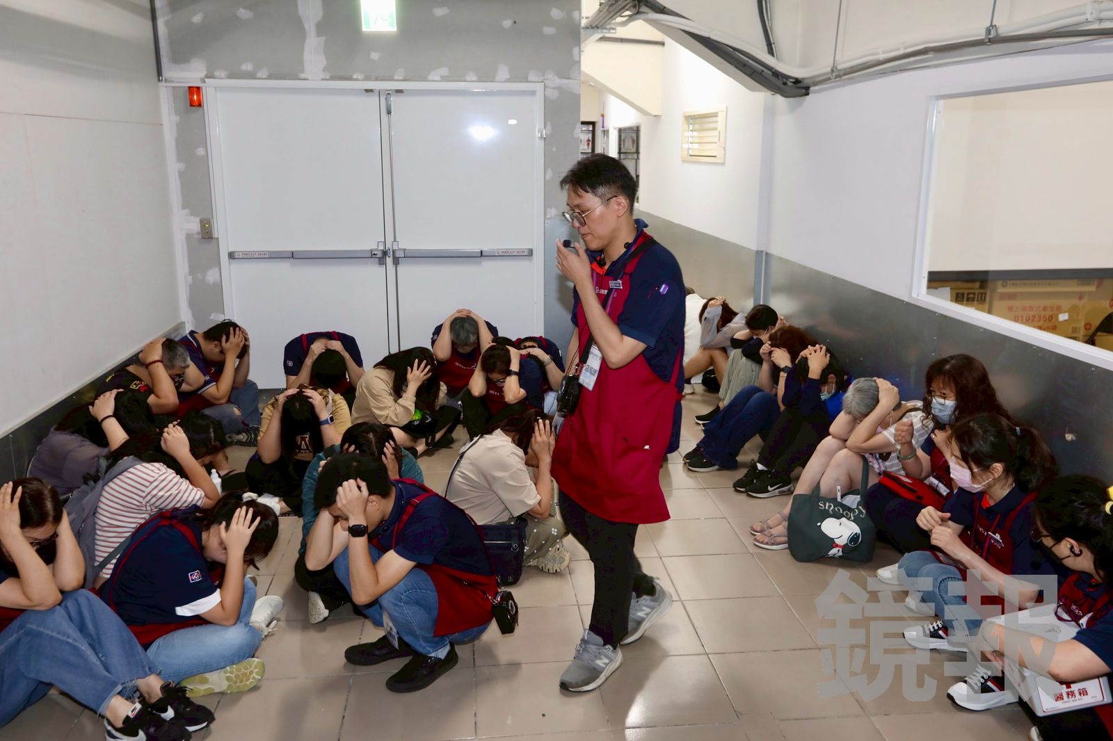 店長化身指揮官，引導顧客以雙手護頭的標準避難姿勢，前往地下室。（圖／林煒凱攝）