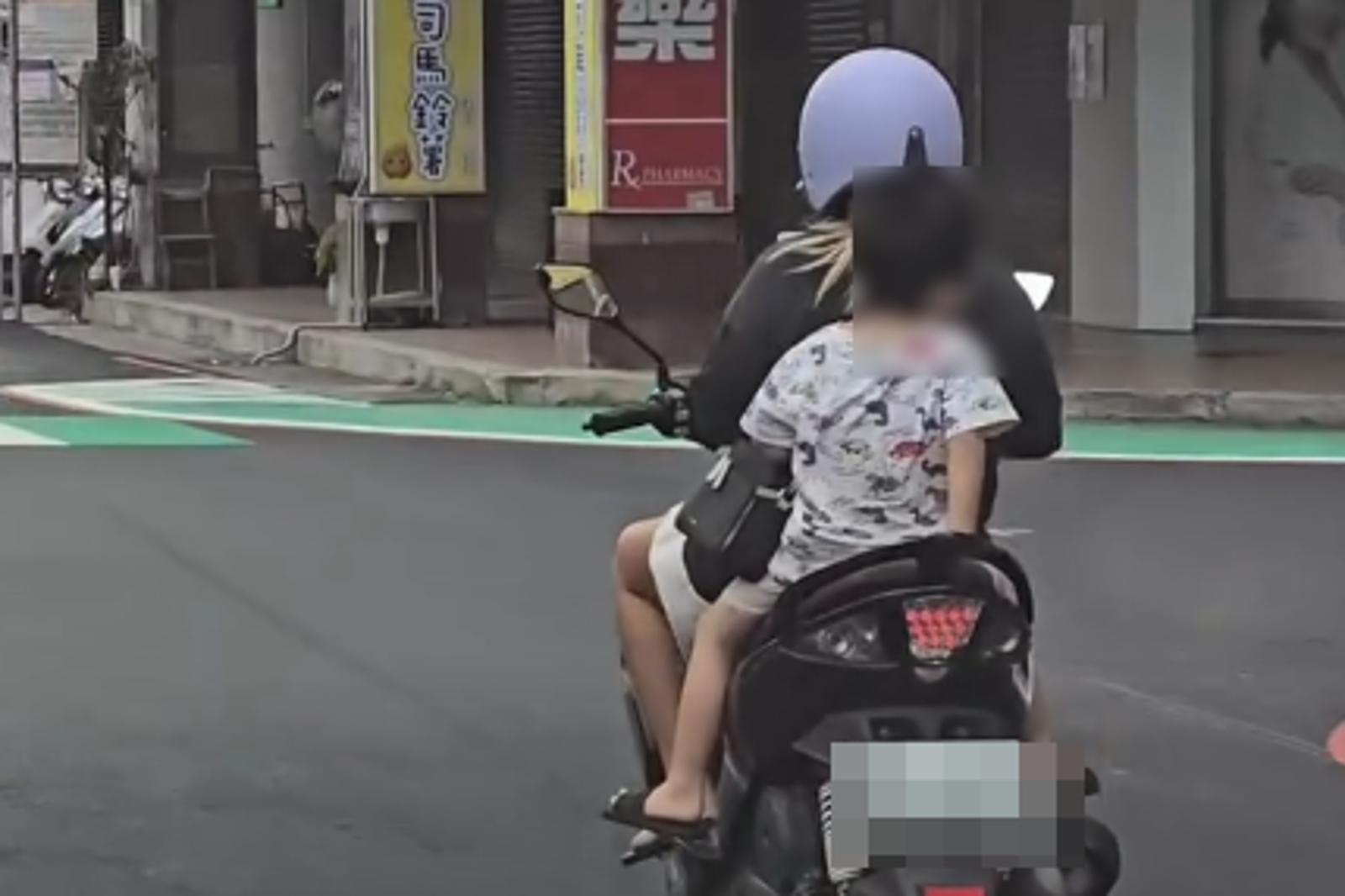 一名女子三貼載2名未戴安全帽孩童上路。圖／翻攝自Threads@antoineisyoung