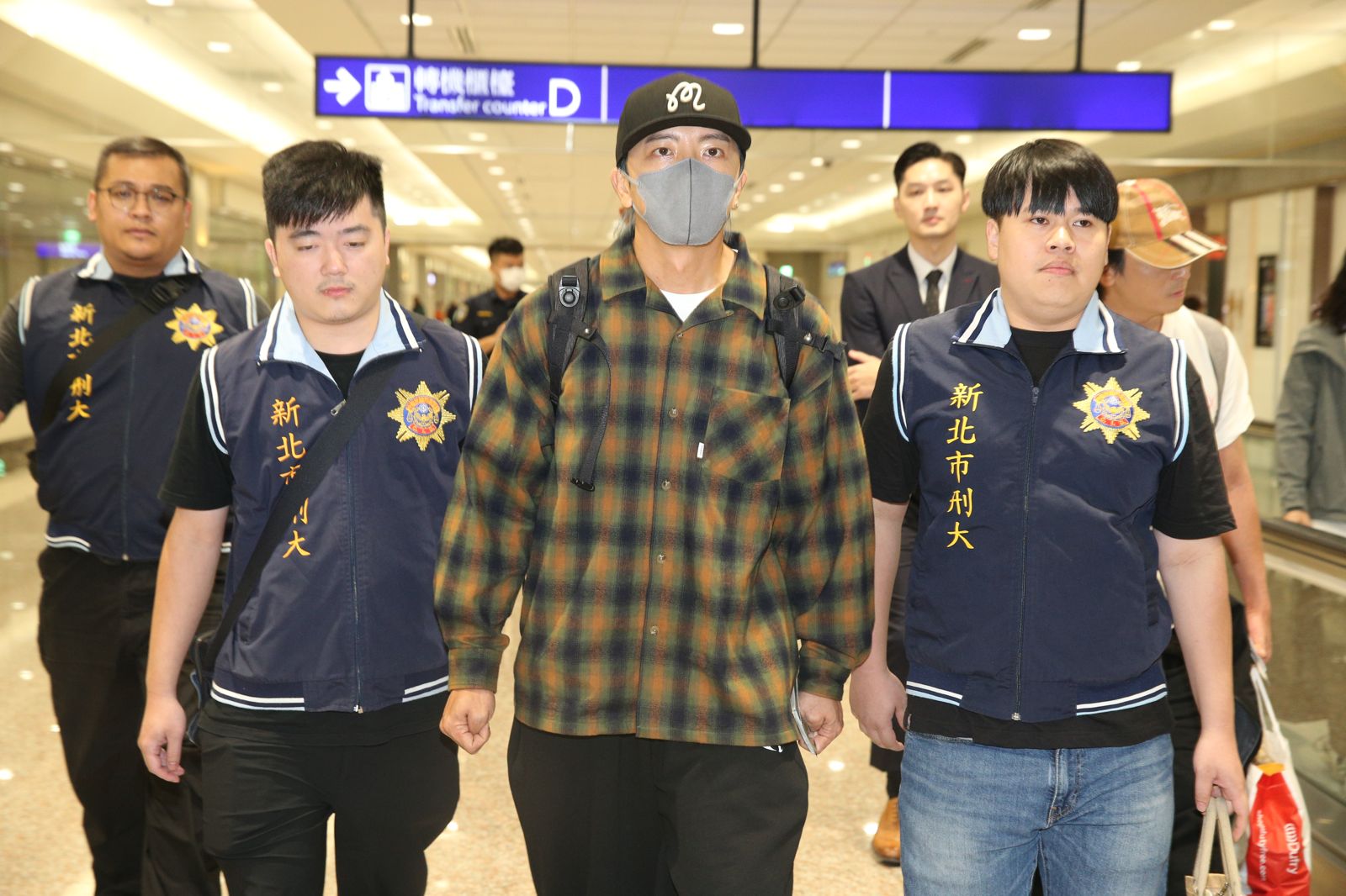 坤達班機落地後,一開始僅由警方戒護,並未上銬,檢察官當時解釋,考量機場為公眾場合且尚未執行「拘提」這個動作,所以不需上銬。桃園機場記者聯誼會提供