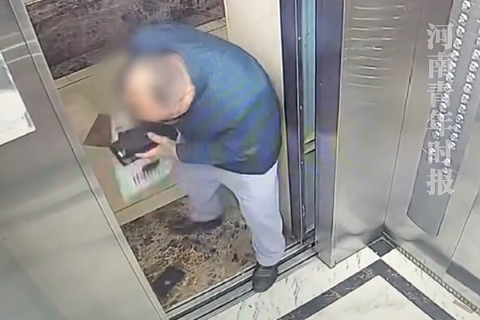 中國阿伯擋住電梯門，開箱新手機。圖／翻攝畫面