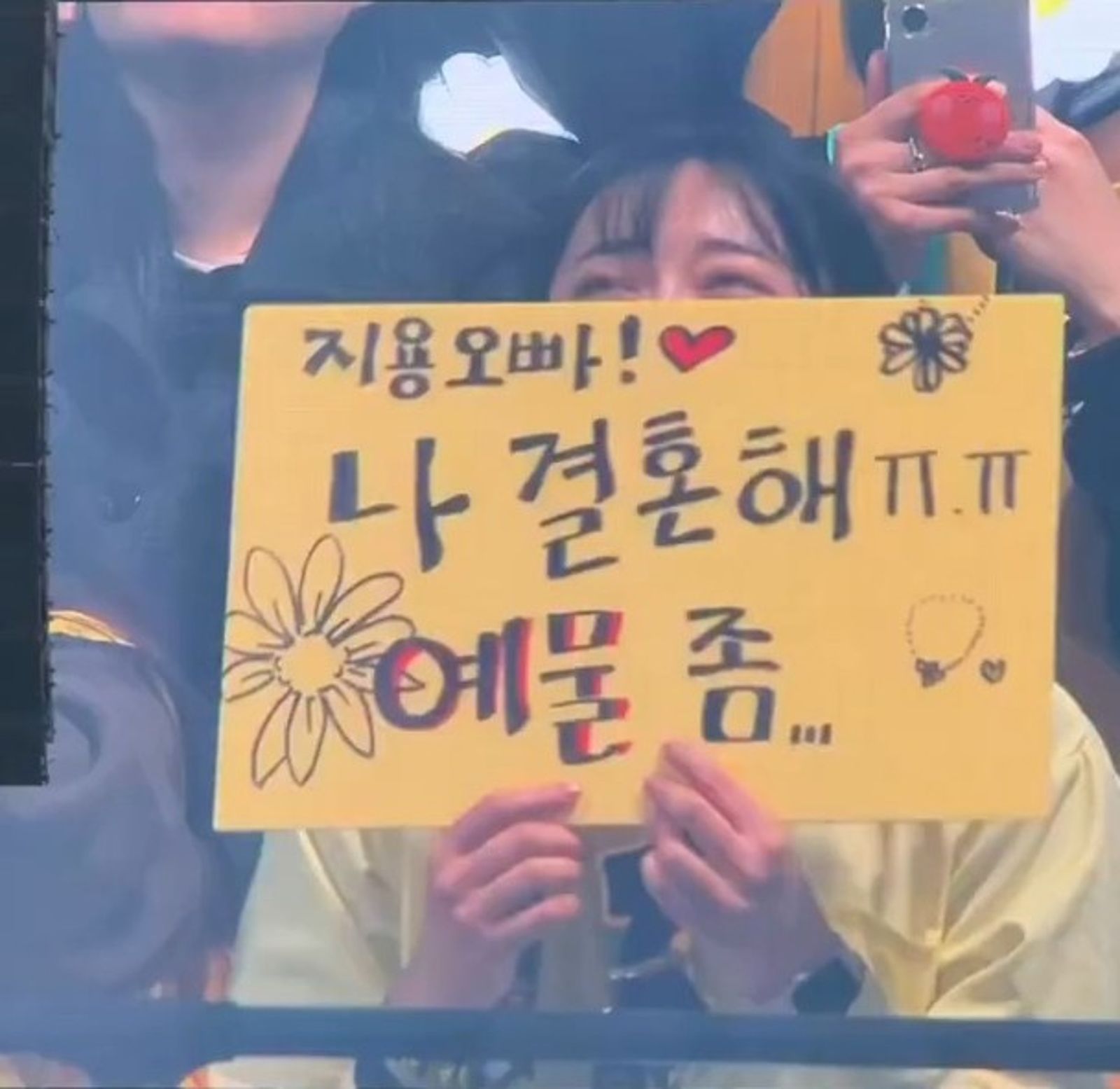 女粉絲舉牌寫著「志龍歐巴，我要結婚了，結婚禮物...」沒想到GD大手筆送出聯名項鍊。翻攝X