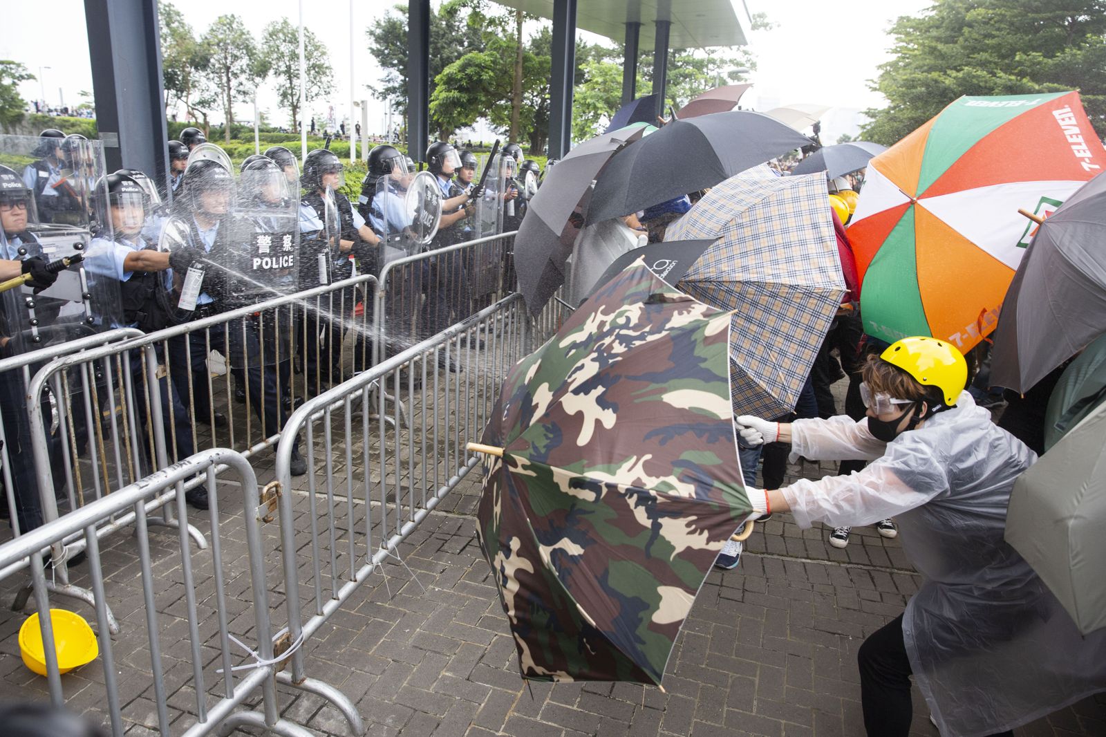 2019年6月12日「反送中」警民衝突，警方噴灑辣椒水，民眾以雨傘阻擋。圖／鏡週刊