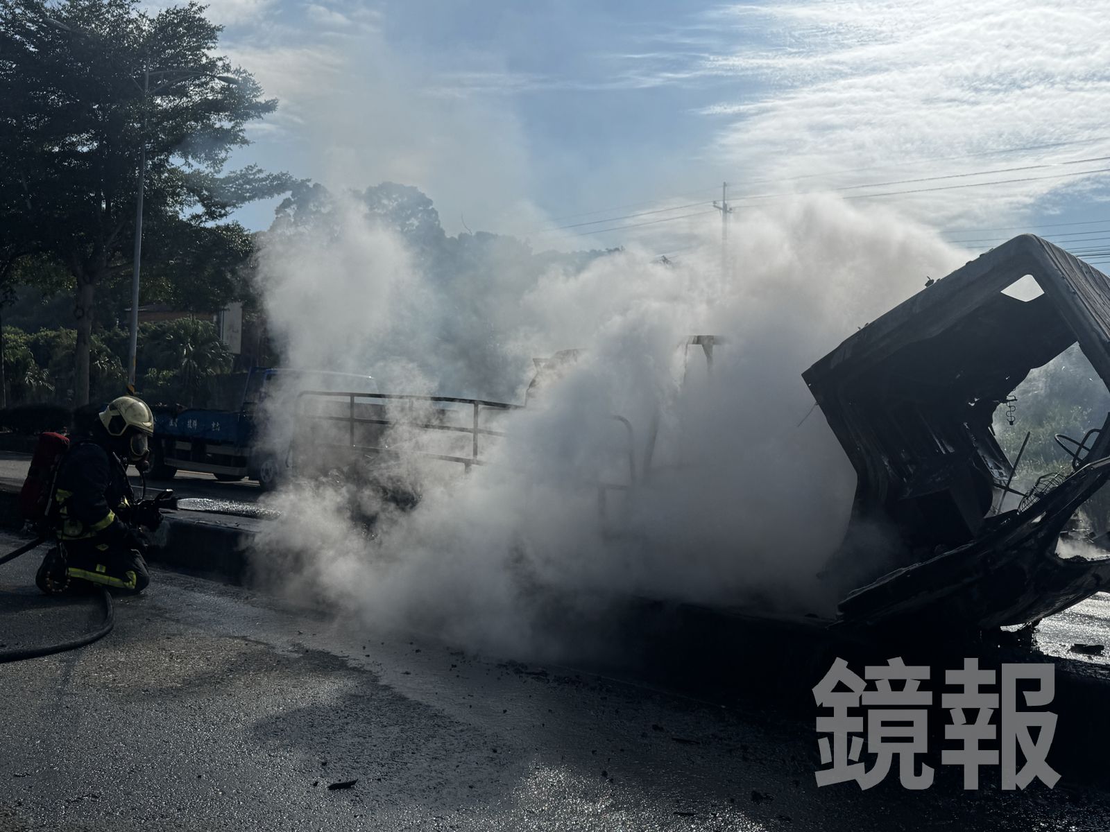 小貨車起火燒毀,冒出陣陣濃煙,消防隊員持續射水灌救。圖/攝影林建鋒