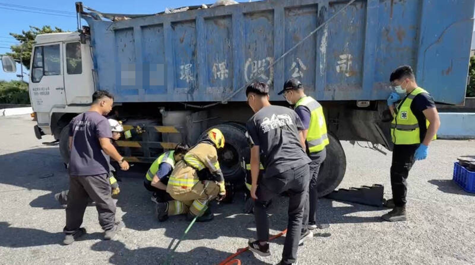 環保車與機車發生碰撞,男騎士受困車底,當場死亡。民眾提供