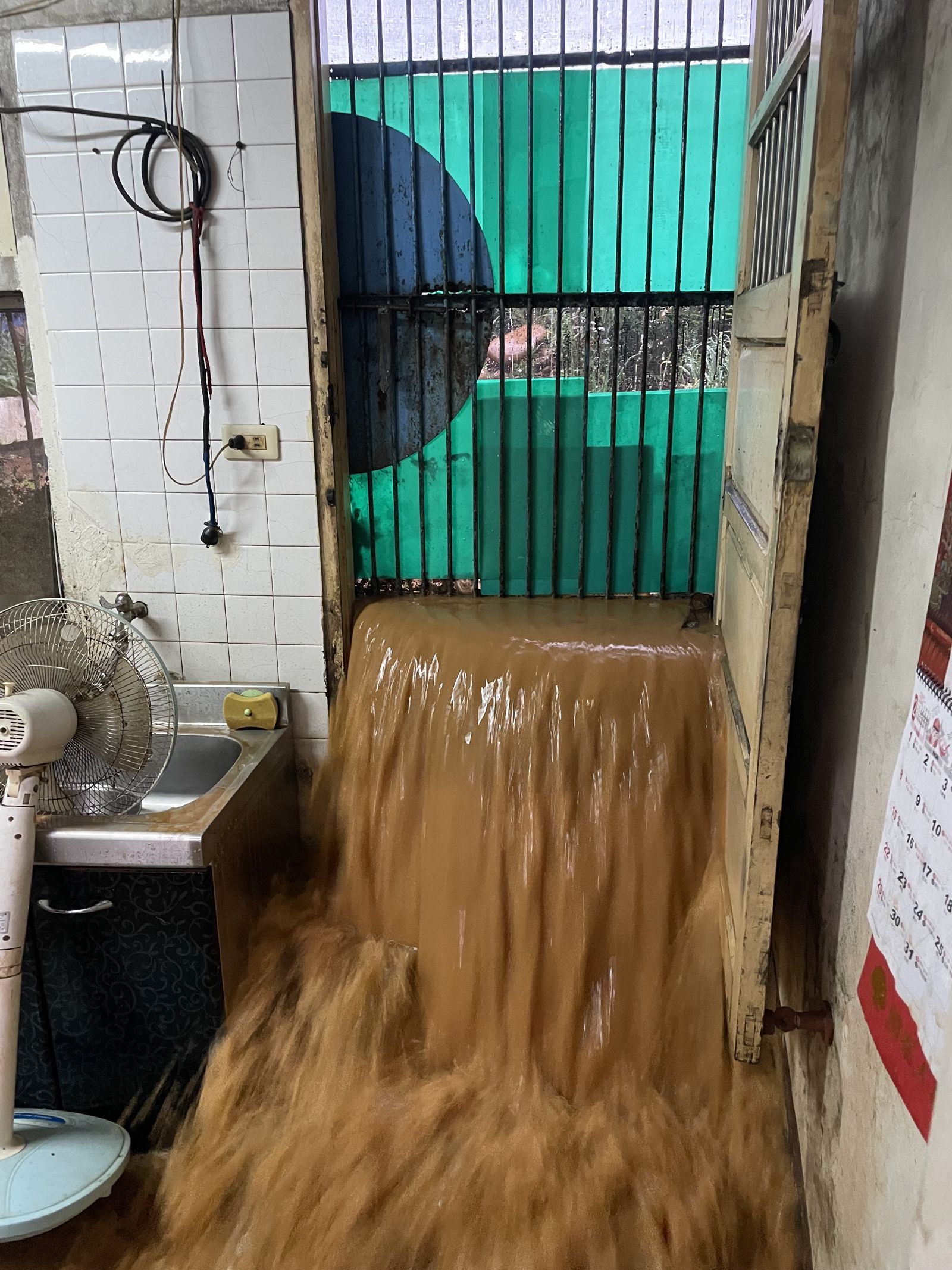 暴雨夾帶大量泥流，如瀑布灌入廚房與客廳。民眾提供