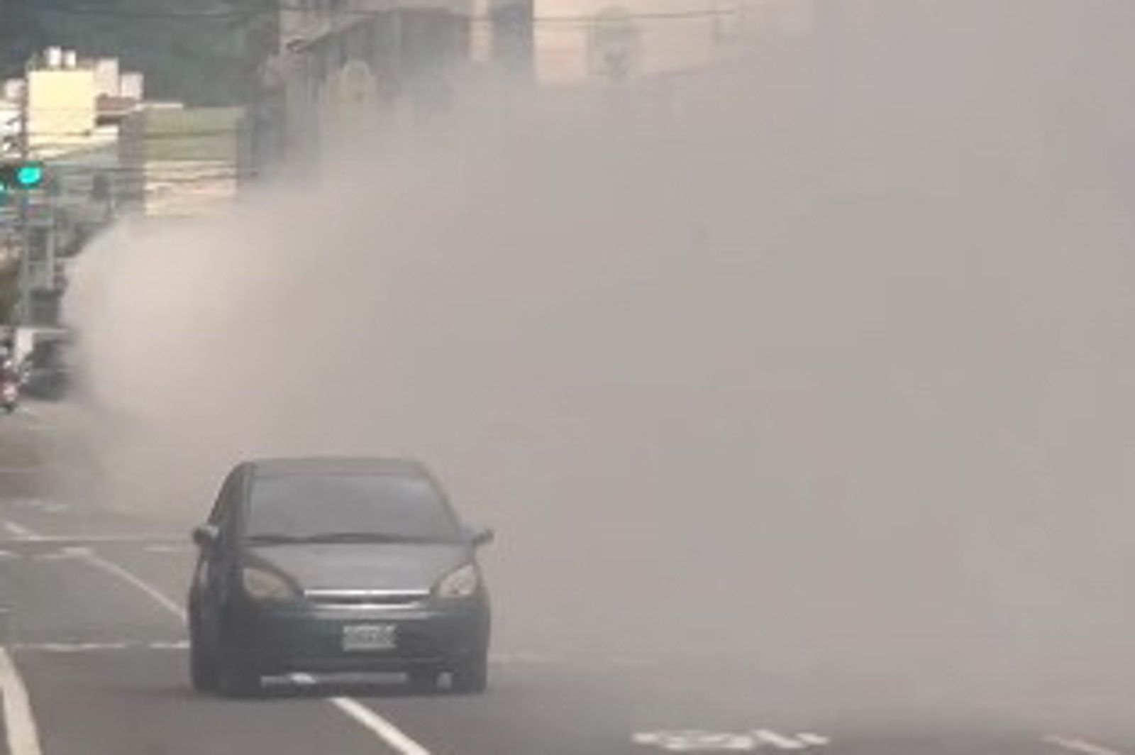 大型吊車的濃濃白煙幾乎遮蔽行車視線,路過車輛只能小心減速。圖/threads授權 chen.__.222