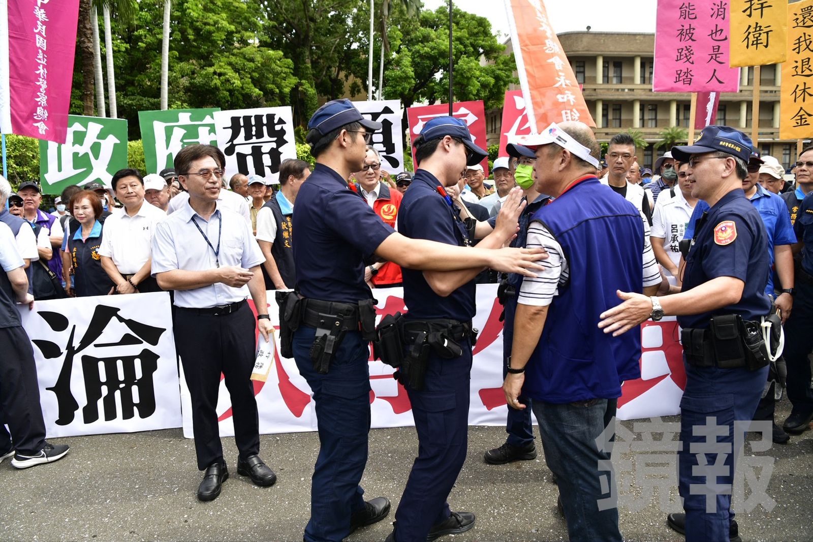 過程中有名退休警消上前欲向行政院代表嗆聲，遭在場員警包圍阻止。（圖／李智為攝）