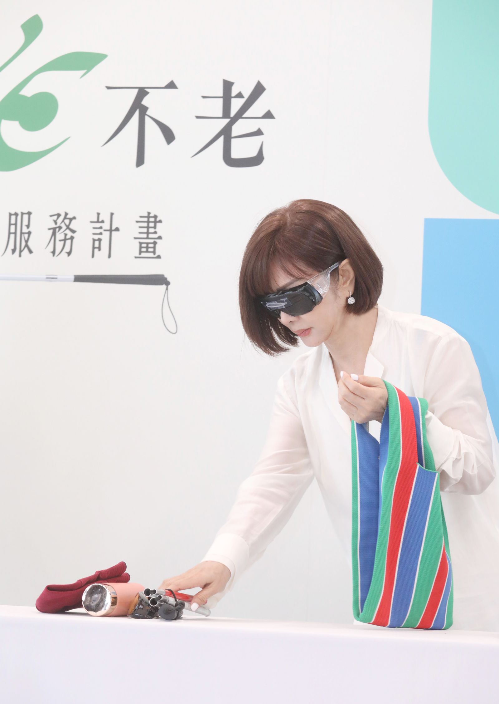 陳美鳳在記者會上戴上視覺模擬眼鏡進行闖關。圖/愛盲基金會