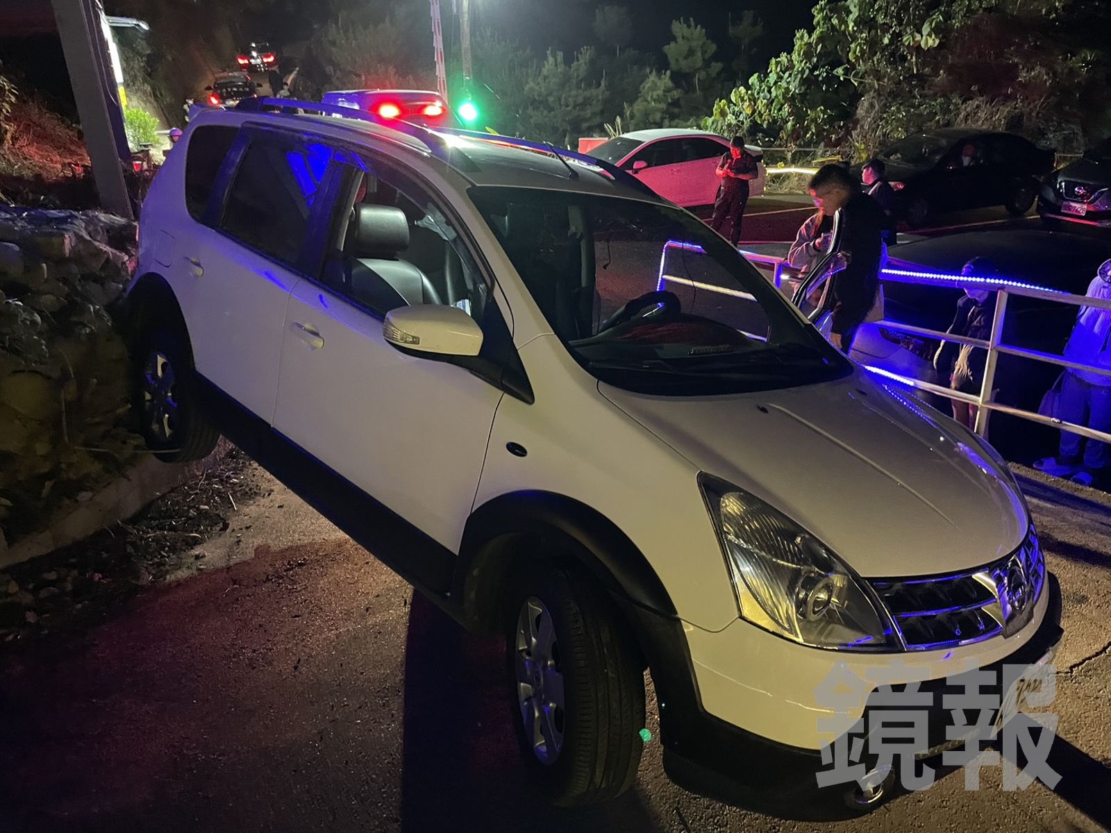 白色轎車倒車卡到邊坡駁坎，車輪騰空，疑因高低差往後滑動翻覆，發生意外。民眾提供
