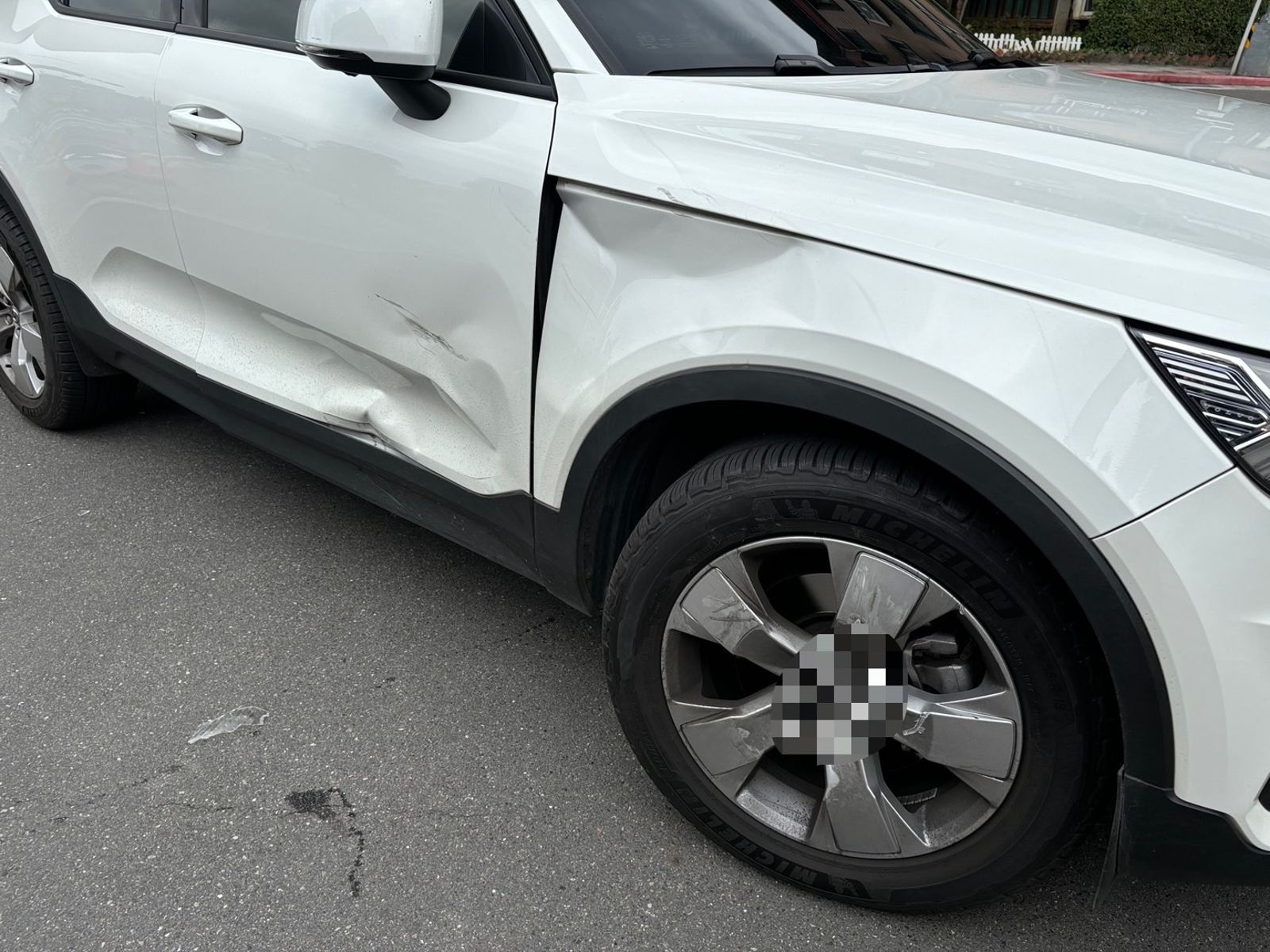 白色轎車副駕駛座車門周邊整個凹陷。翻攝畫面