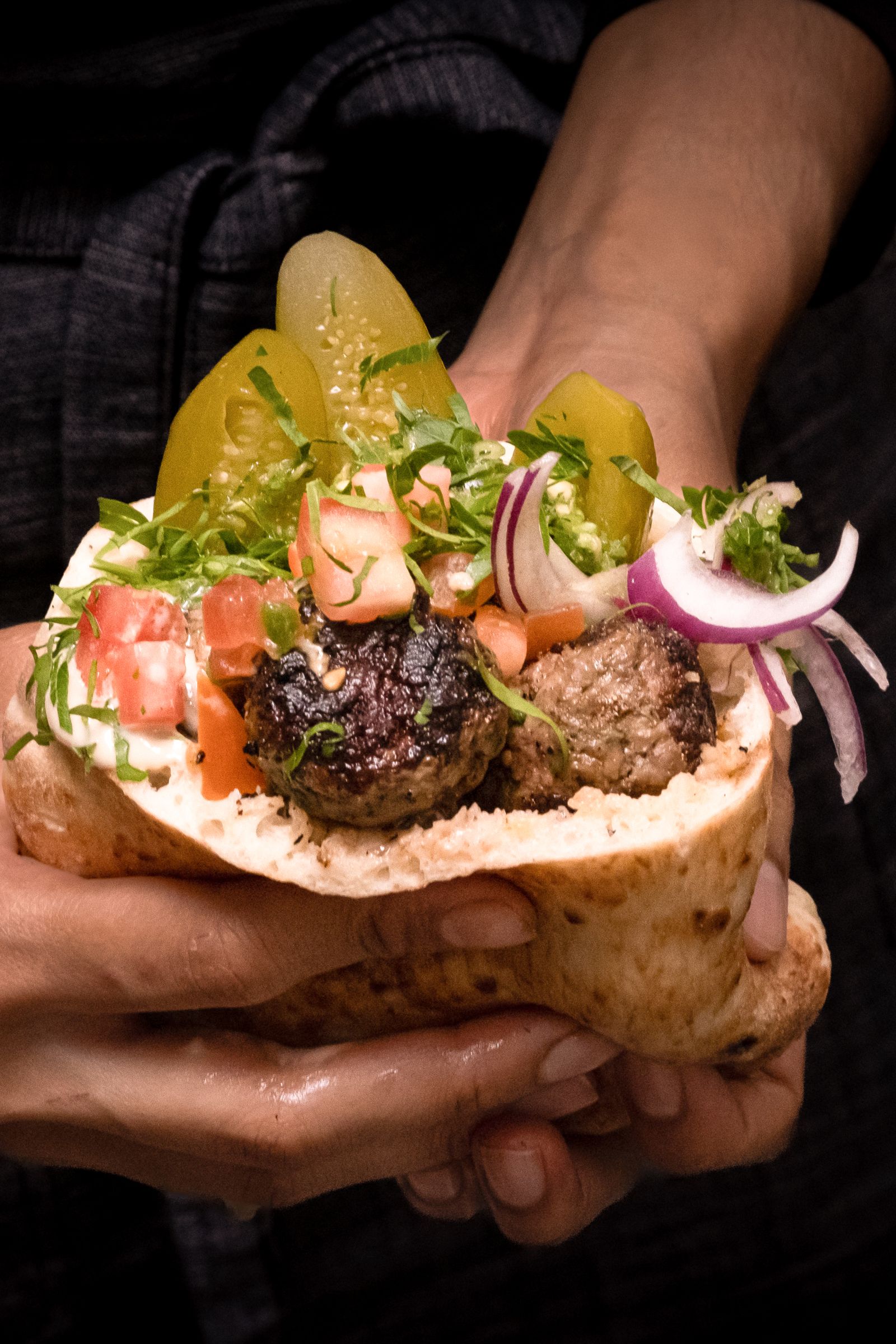 「Lamb Kabab羊肉烤串」羊腹肉炭烤後表面帶焦香,咬開會流出肉汁,羊肉油脂與辣醬、醃菜混合,味道厚但不膩。(Miznon供圖)