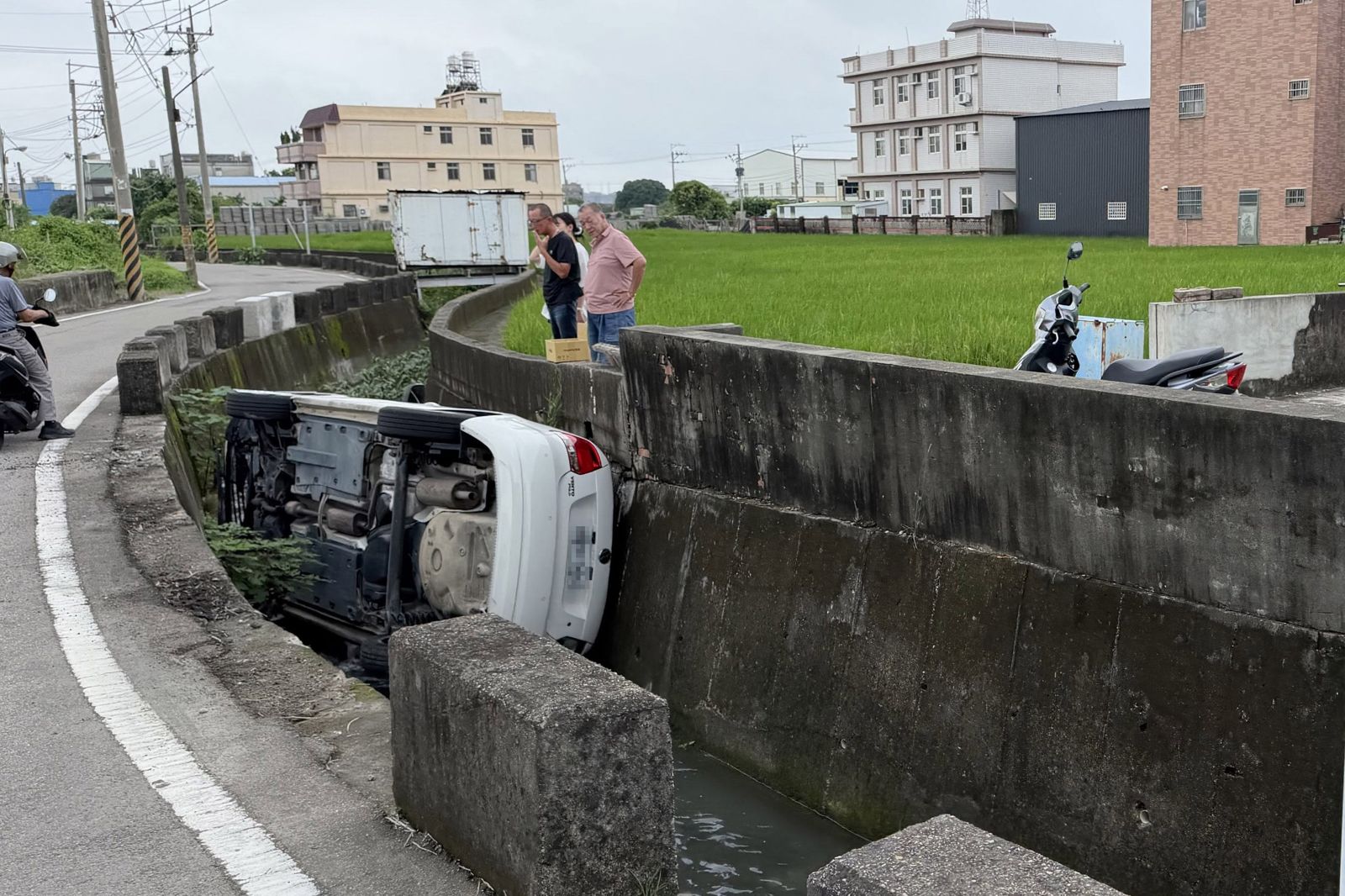 少婦開車「騎上護欄」神準側翻塞進水溝!3歲兒、5歲女受困車內 熱心民眾急奔救人