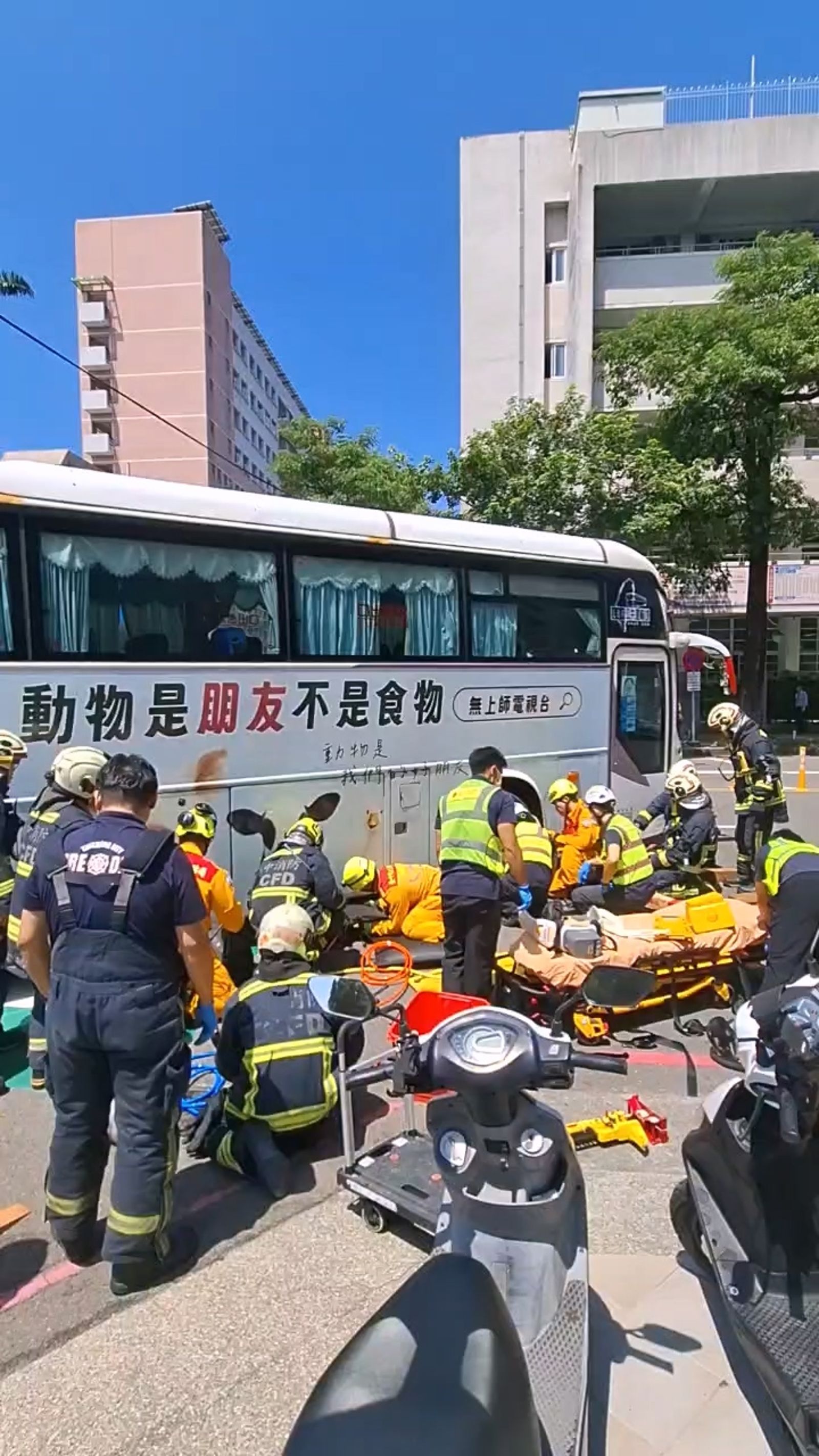 新加坡籍婦人受困在國光客運右前輪下,已無生命跡象,消防隊員到場展開搶救。圖/民眾提供