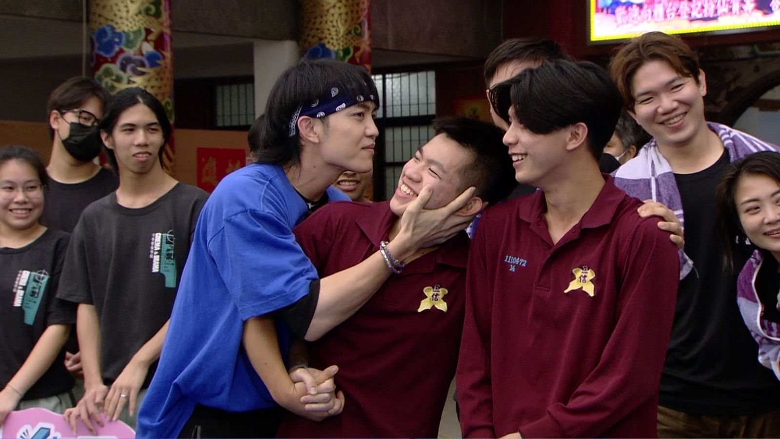 郭忠祐作勢親男同學。民視提供