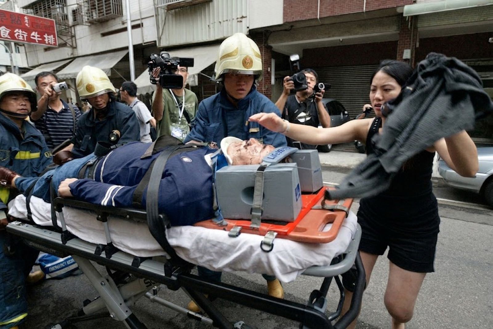 台中角頭翁奇楠遇伏擊遭槍殺,現場已無生命跡象,親眼目睹慘案的女友楊思莛(右)焦急陪同送醫。翻攝畫面