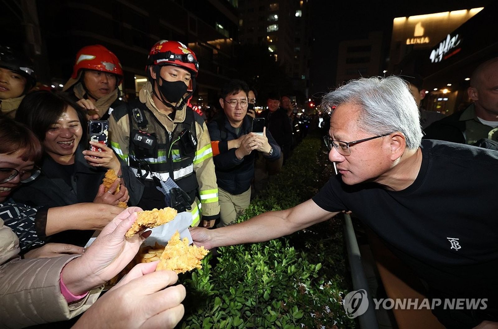 黃仁勳在現場分送炸雞給民眾。圖/翻自《韓聯社》