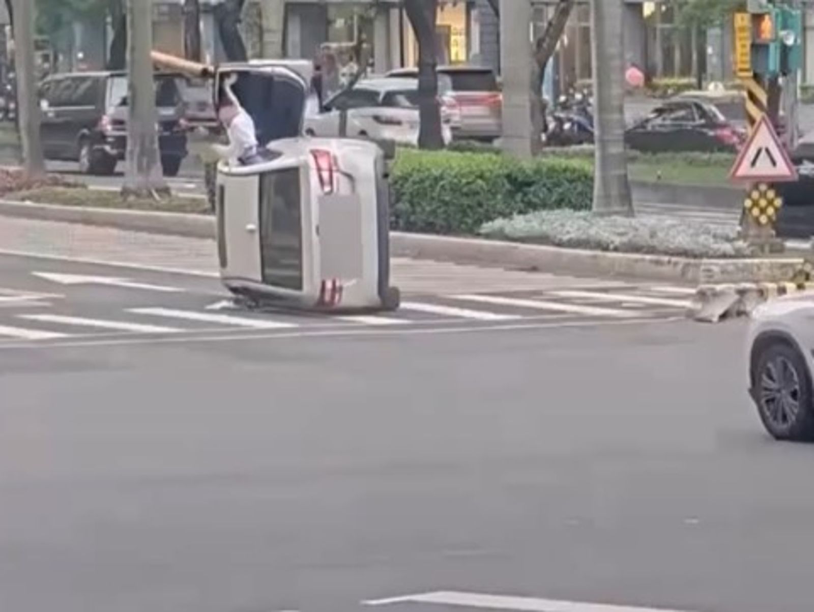 命大！大安區轎車「騎庇護島」翻覆180度　駕駛開車門爬出脫困　