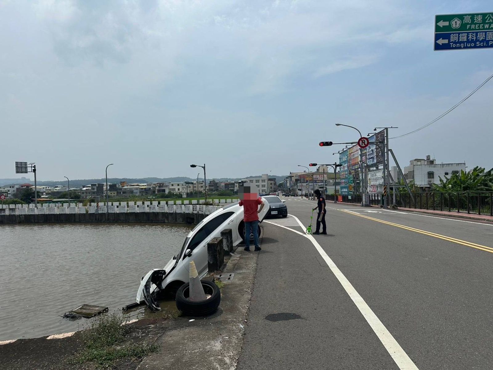 白色賓士轎車撞斷護欄,車頭斜插入水田、後輪懸空,所幸駕駛鄭男輕傷沒有大礙。民眾提供