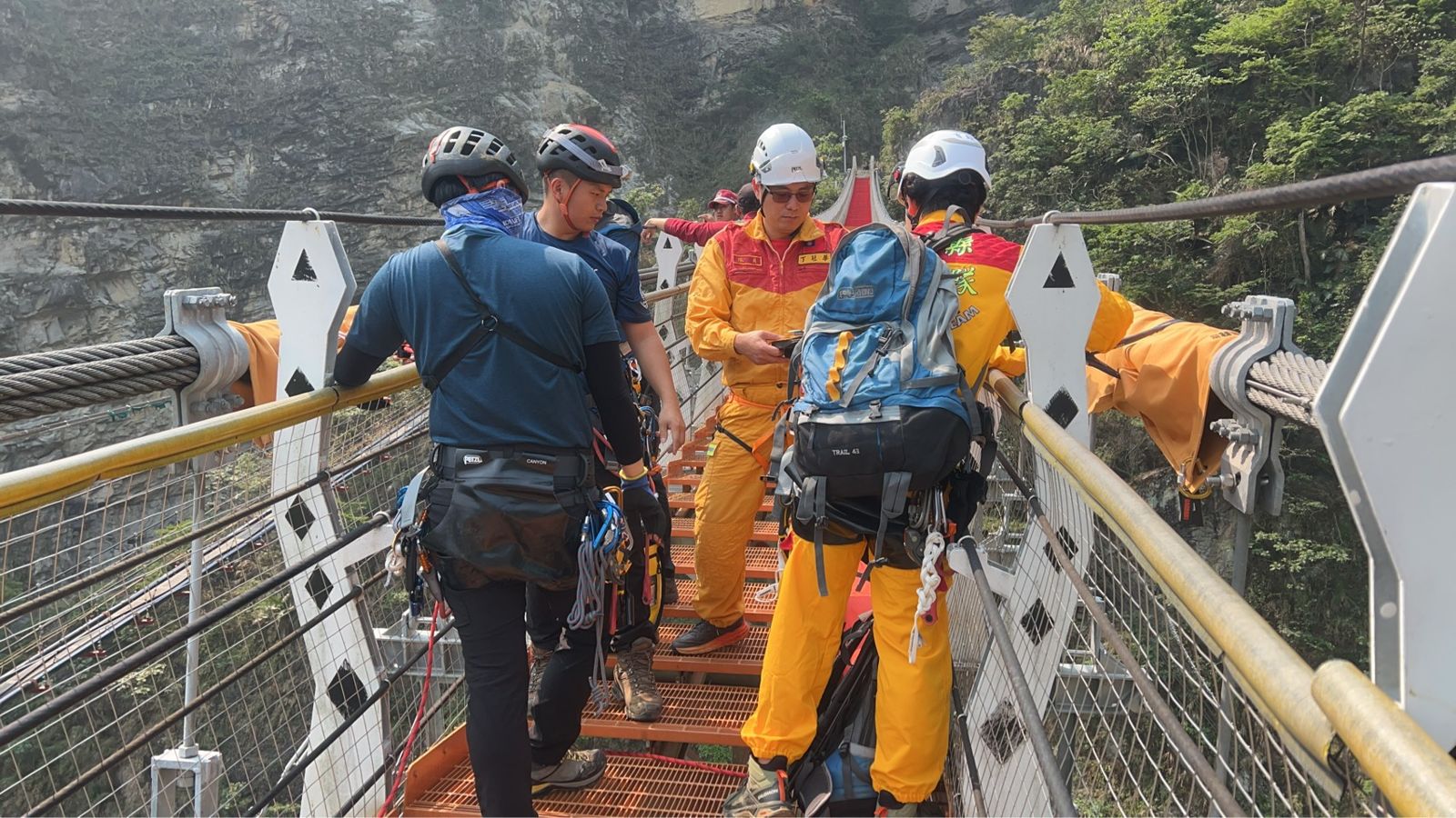 救難人員在吊橋的橋面架設繩索垂降設備。民眾提供