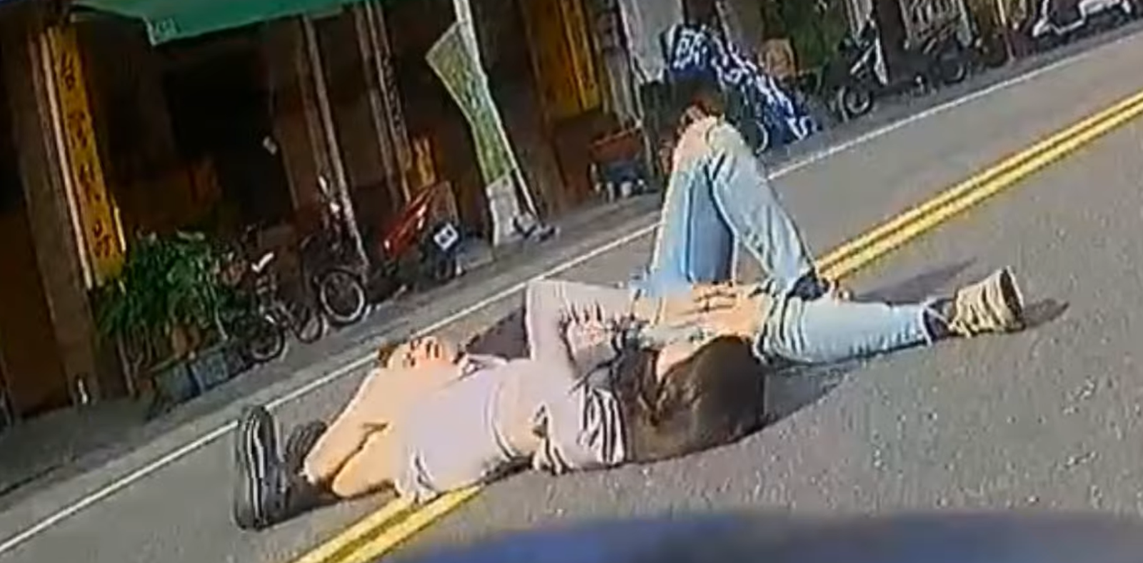 機車行車紀錄器明顯拍下一對男女躺在路中央。翻攝「Wowtchout - 地圖型行車紀錄器分享平台」