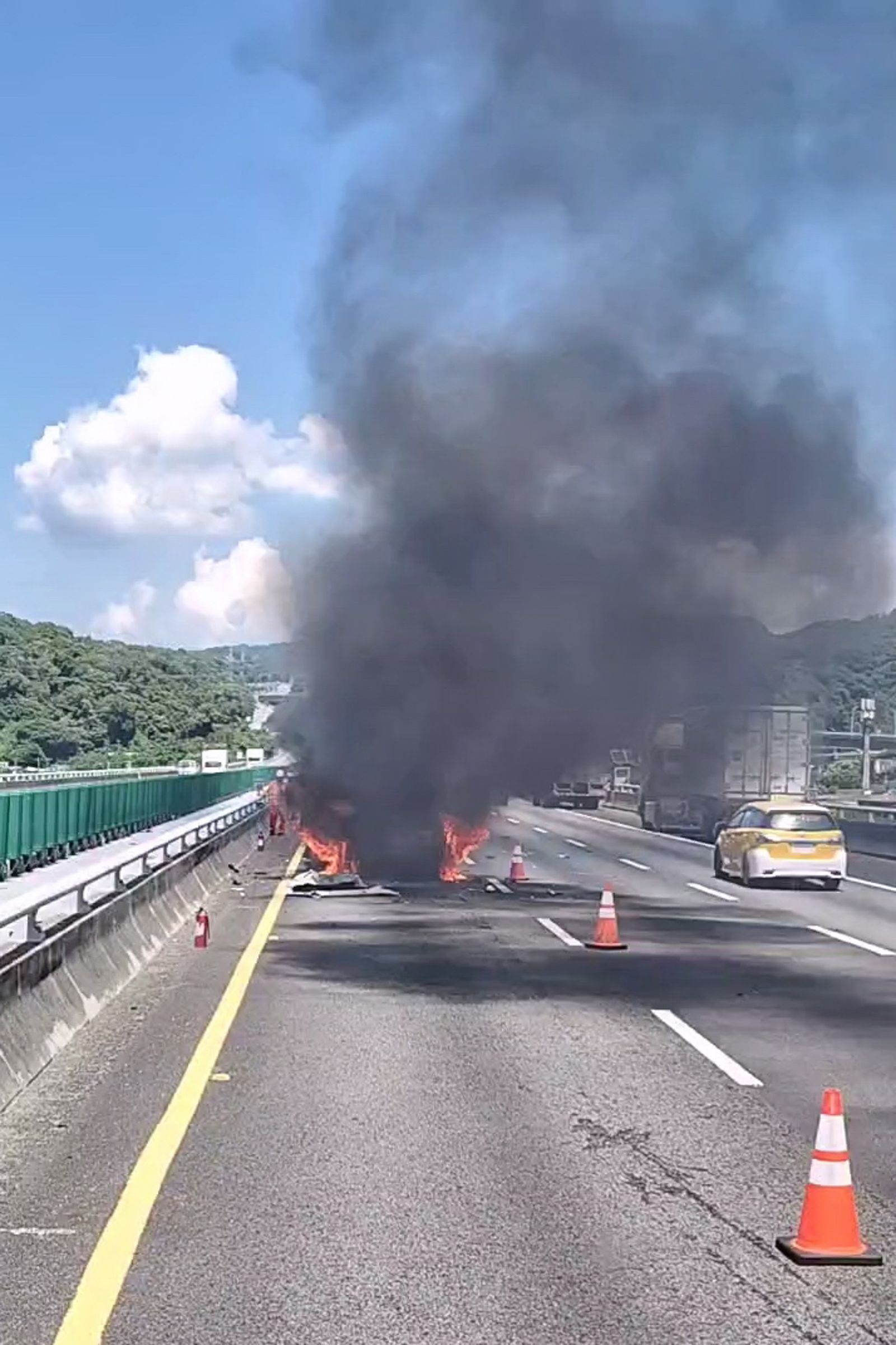 白色休旅車在內車道撞上緩撞車陷入火海,冒出陣陣黑色濃煙。圖/民眾提供