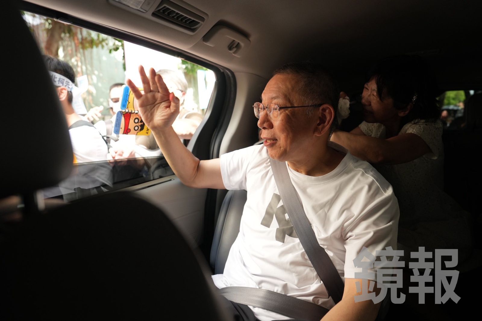 柯文哲交保搭車離開前，揮手跟小草致意。民眾黨提供