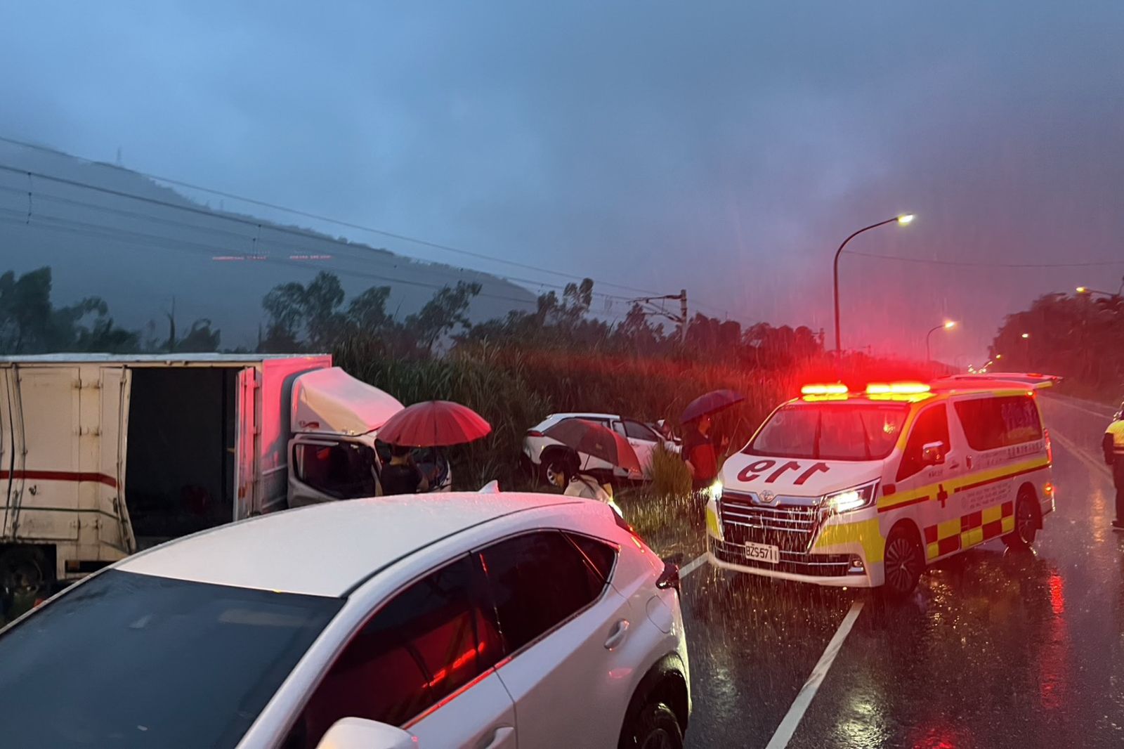 花蓮光復鄉台9線發生轎車與貨車碰撞車禍,造成3人重傷,其中一對母子無生命跡象,消防隊員冒著大雨展開搶救。圖/民眾提供