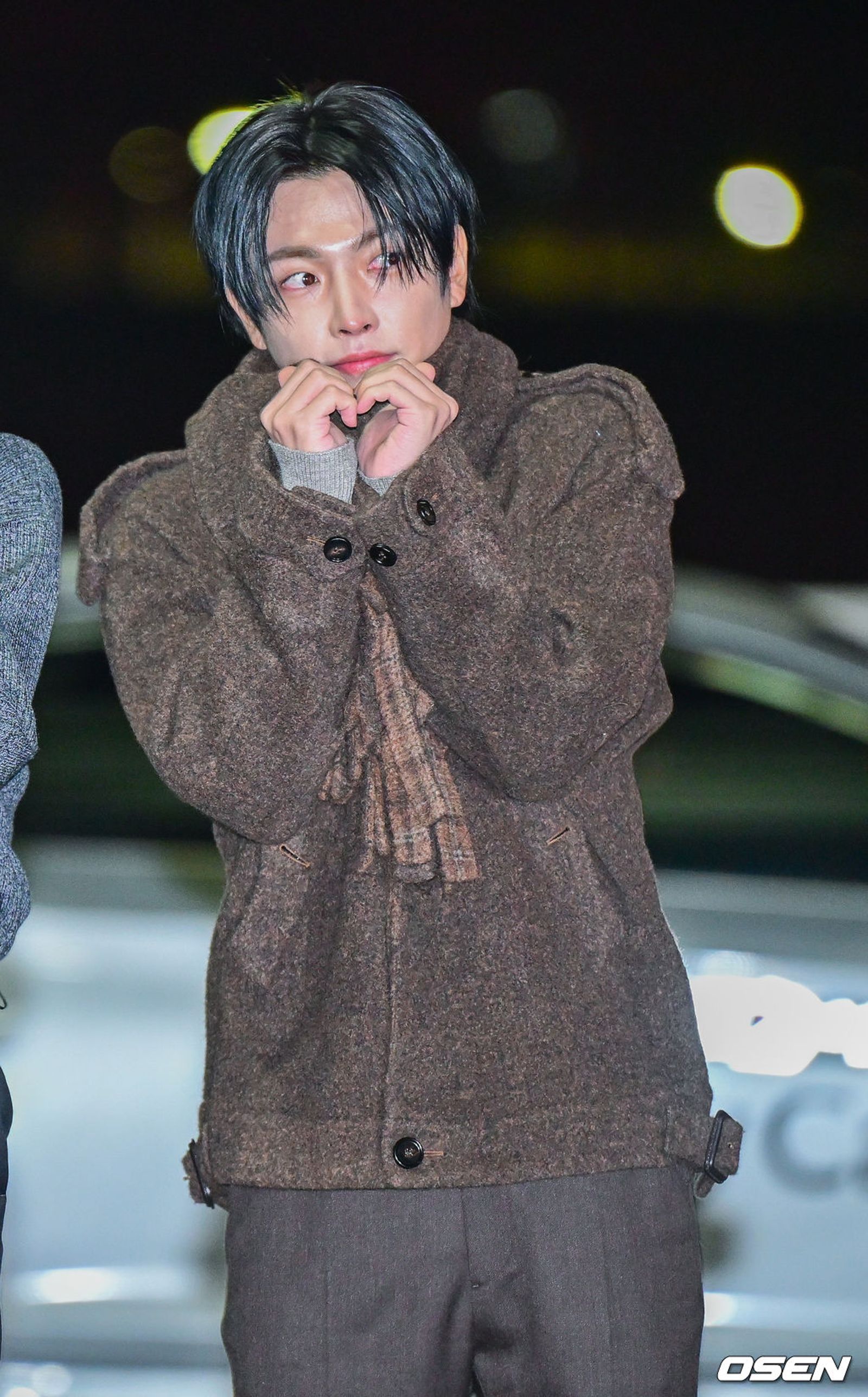 HONGJOONG冷到縮成一團，照樣比出愛心。翻攝OSEN