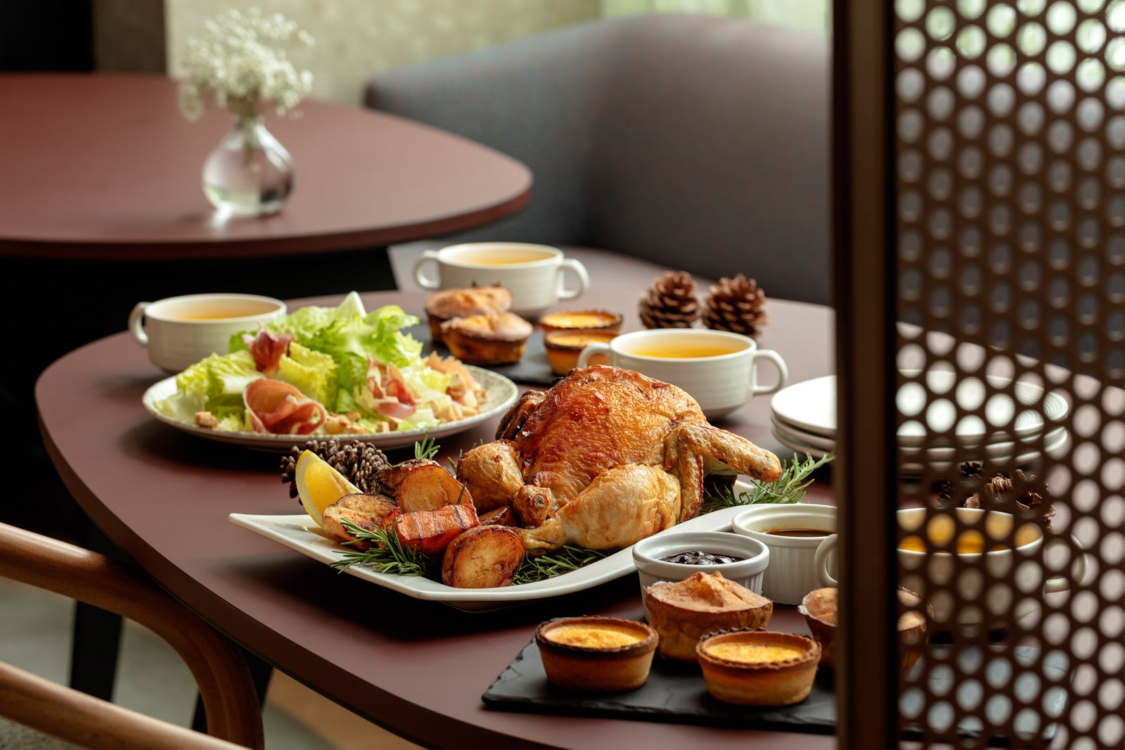 「野蕈香料鑲雞」4人餐可以吃到整隻烤全雞、帕瑪雞肉凱薩沙拉、約克夏布丁、南瓜濃湯、起司火腿鹹派、主廚甜點及綜合莓果醬與雞肉醬汁、粉紅氣泡酒。（2,180元／套，國聯大飯店供圖）