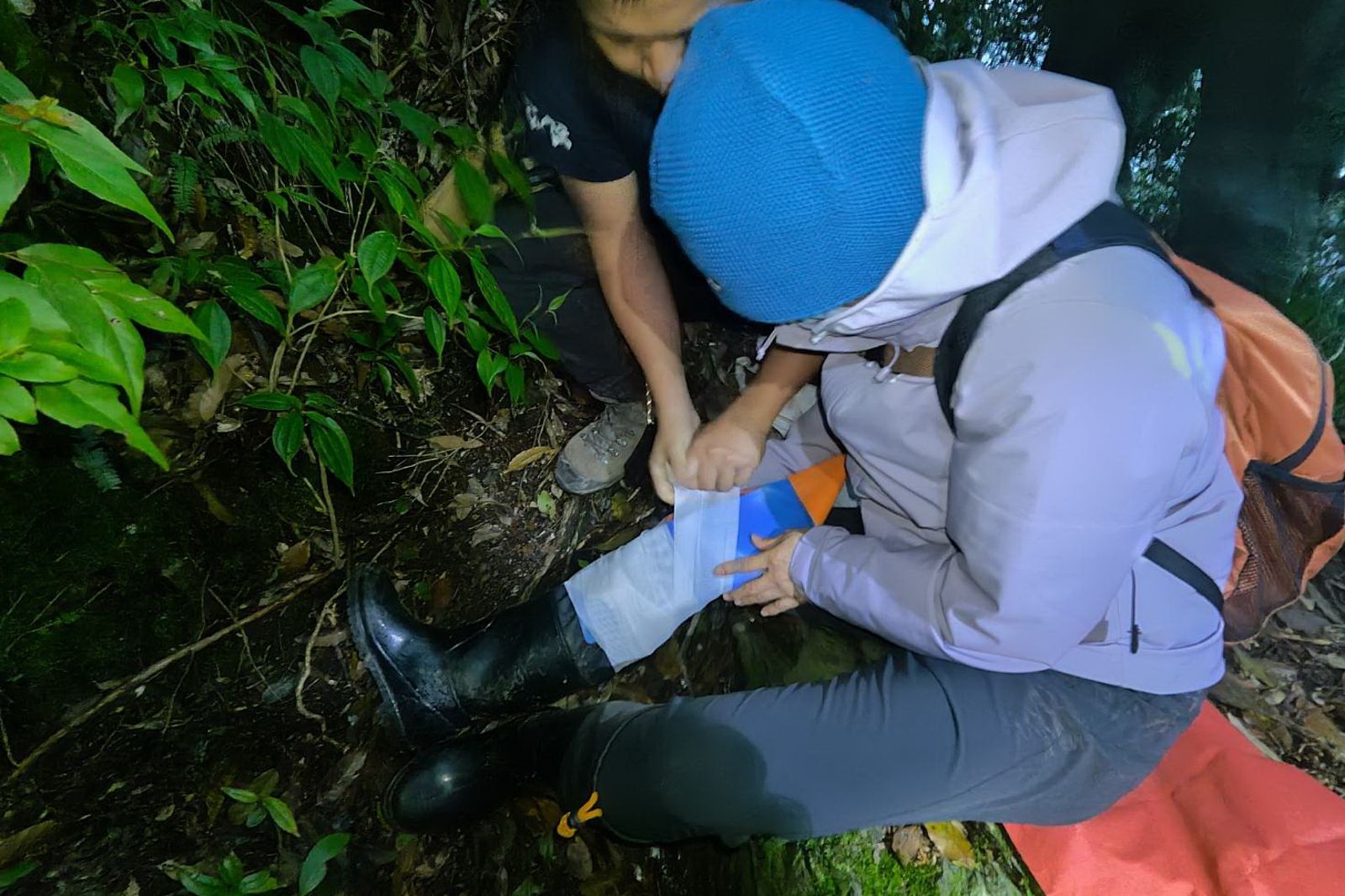 吳姓女登山客摔傷右膝，搜救隊員先行檢傷、初步醫療處置。民眾提供