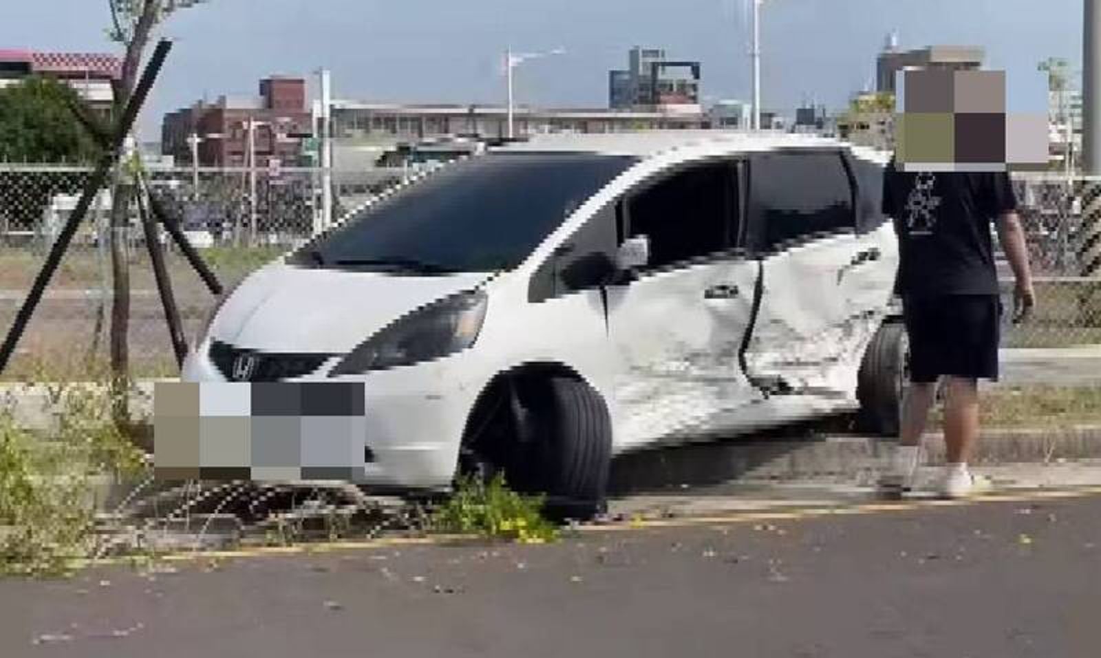 白色轎車與救護車相撞後,左側車門凹陷。讀者提供
