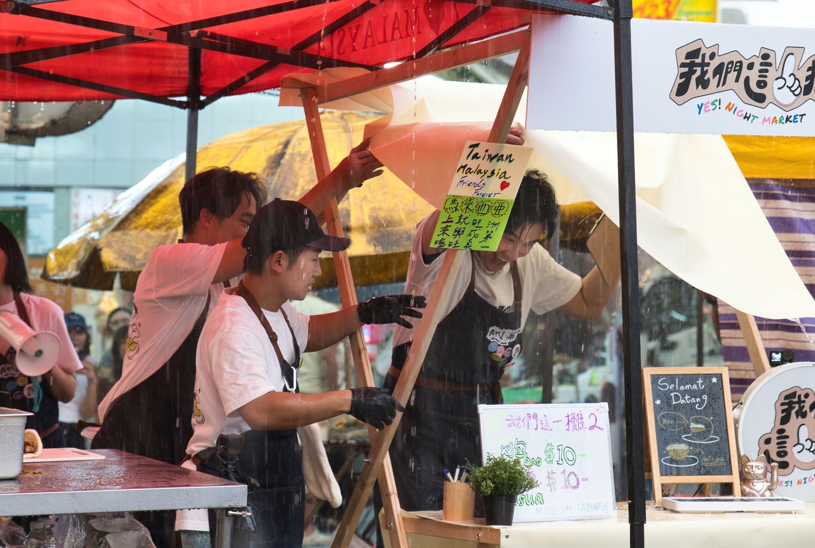 我們這一攤2 馬來西亞出攤遇大雨，淋謝佳見一身濕。華視、三立提供