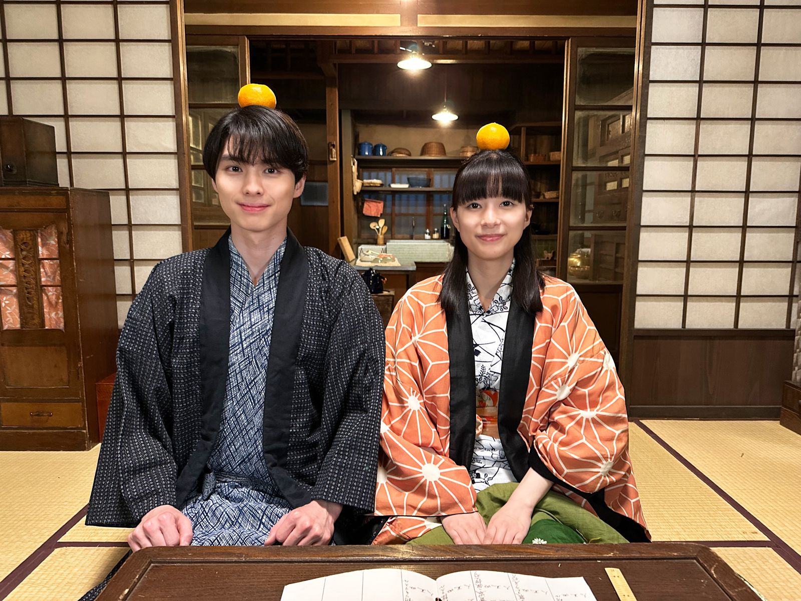 兩人將橘子頂在頭上拍花絮照，被網友大讚可愛。翻攝官方X