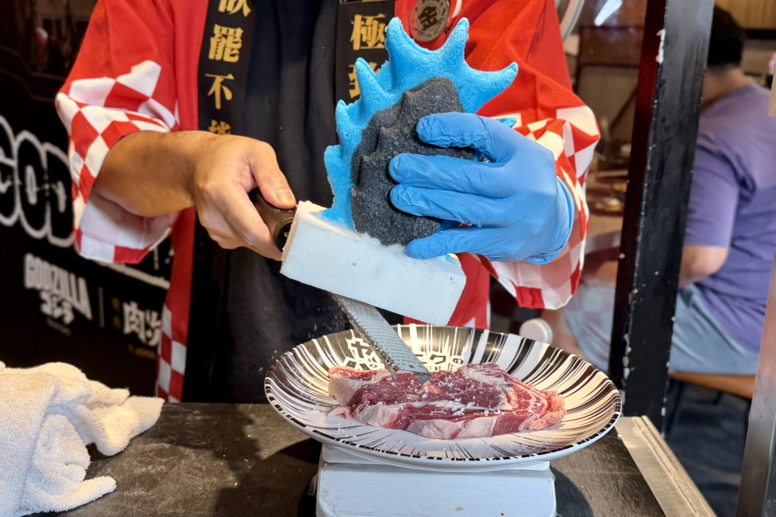「哥吉拉限定現切原塊肉車」會推至桌邊,現切肋眼牛排,並現刨哥吉拉背鰭造型鹽塊提味。