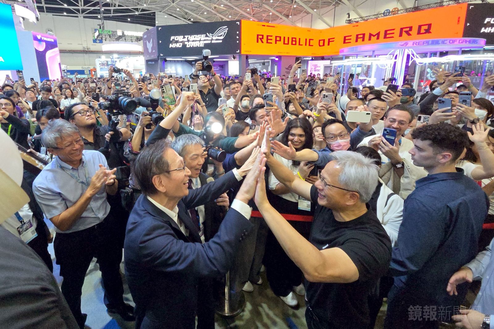 黃仁勳來到華碩攤位，與華碩董事長施崇棠開心擊掌。