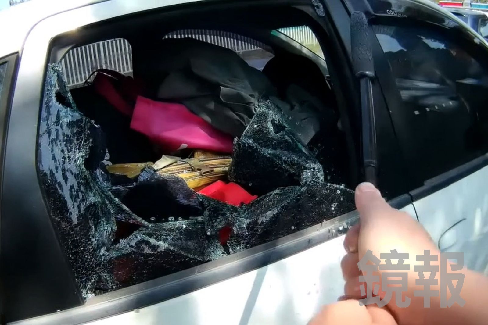 警方持警棍擊破車窗，及時救出女嬰。民眾提供