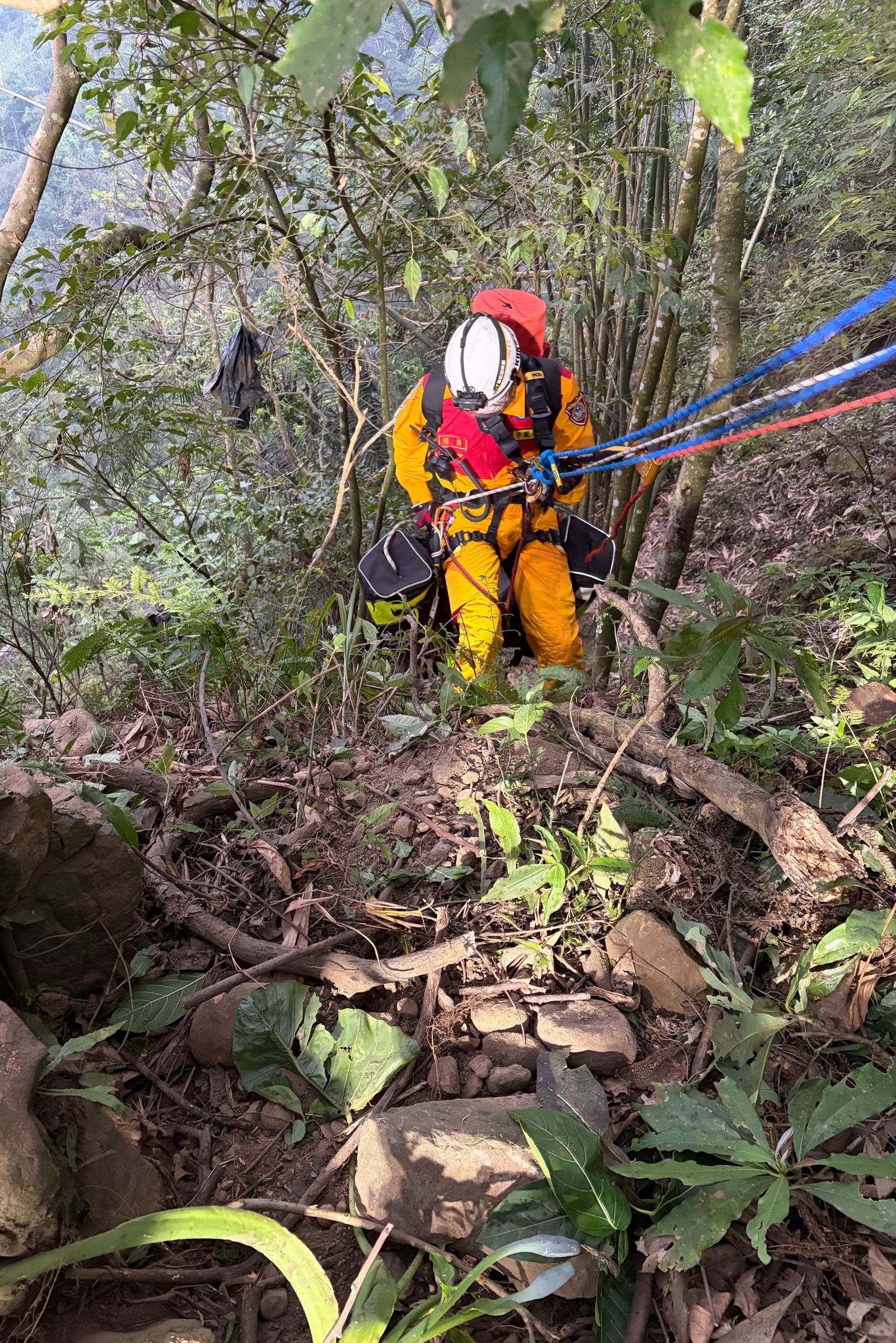 搜救隊員以繩索垂降到陡坡深谷，展開艱辛的救援。民眾提供
