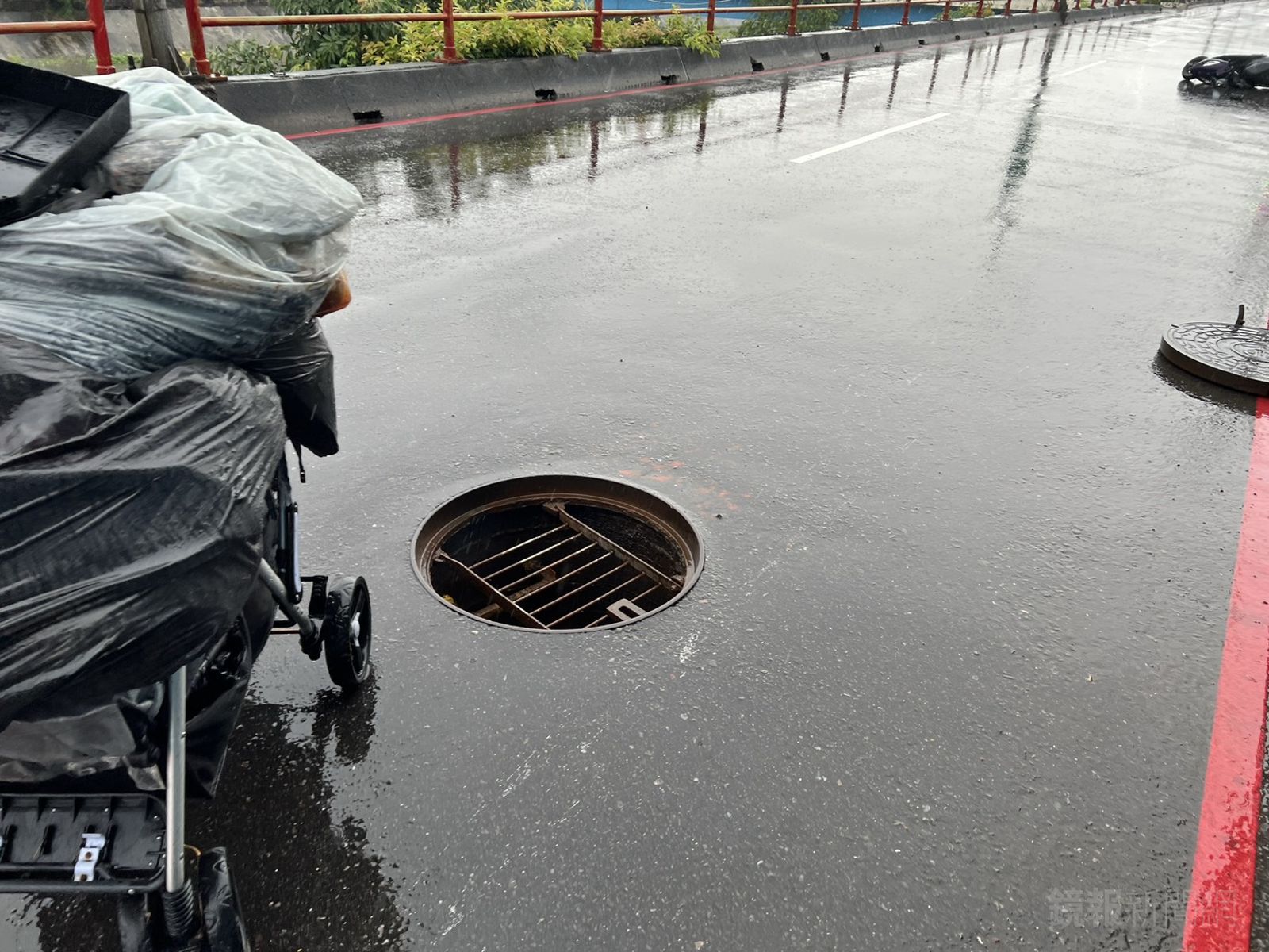 人孔蓋是因小貨車經過或是雨勢過大遭地下水流沖起仍待調查。警方提供
