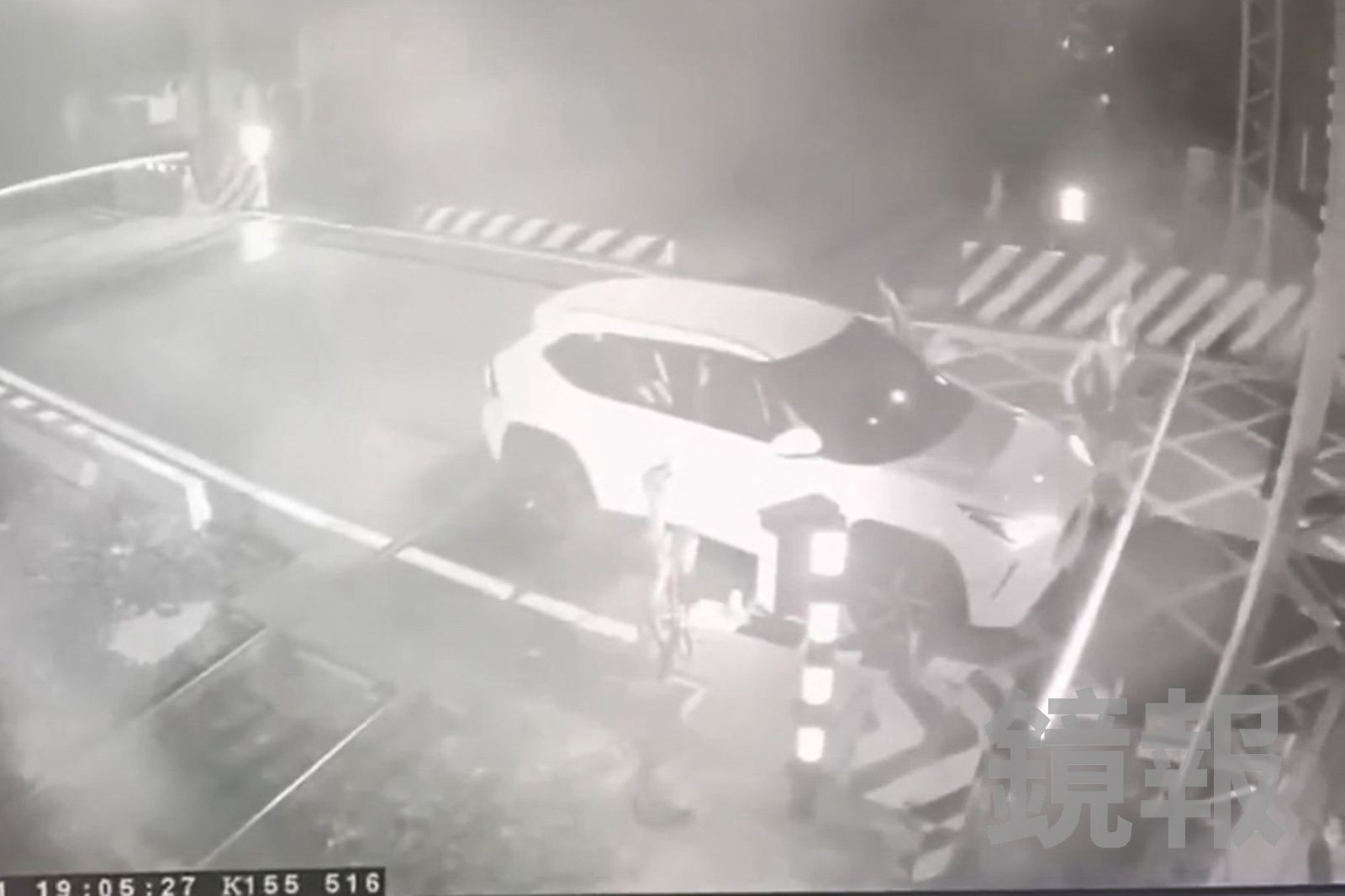 平交道前後遮斷桿都已放下，蘇姓副站長下車，伸手想拉開前方的遮斷桿，卻無法移動。民眾提供