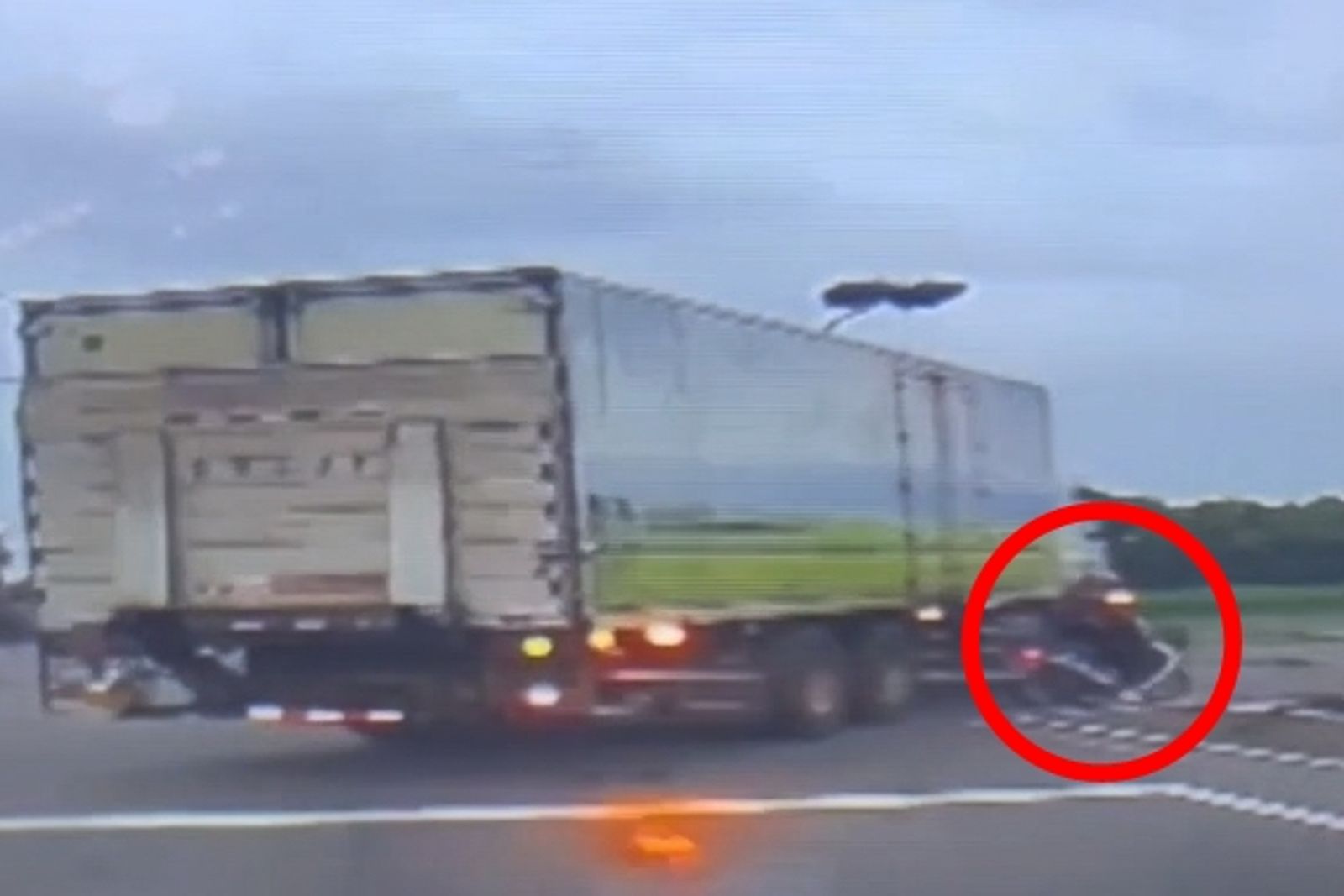 後方轎車駕駛目睹，大貨車右轉與同向機車(紅圈處)發生碰撞。民眾提供