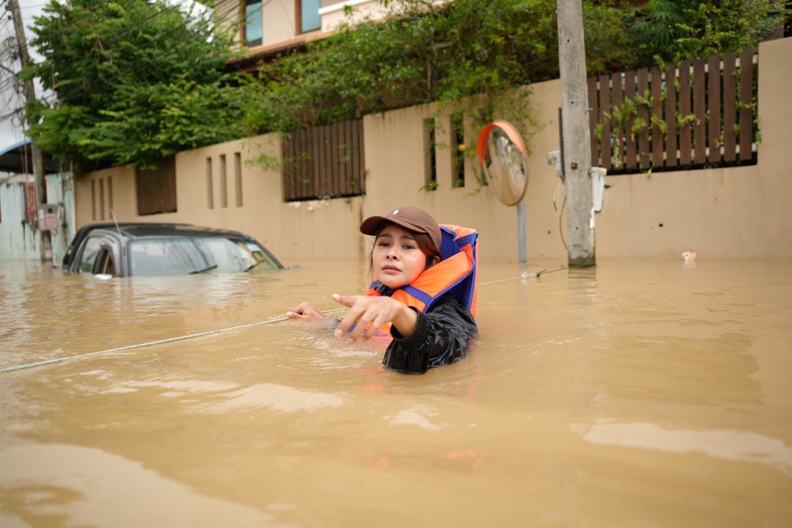 泰國南部百年難見大雨，災情影響超過12.7萬戶家庭，眾議員帕卡儂（Pukkamon Nunarnan）涉水而過，積水高度幾乎滅頂。圖／翻攝Pukkamon Nunarnan臉書
