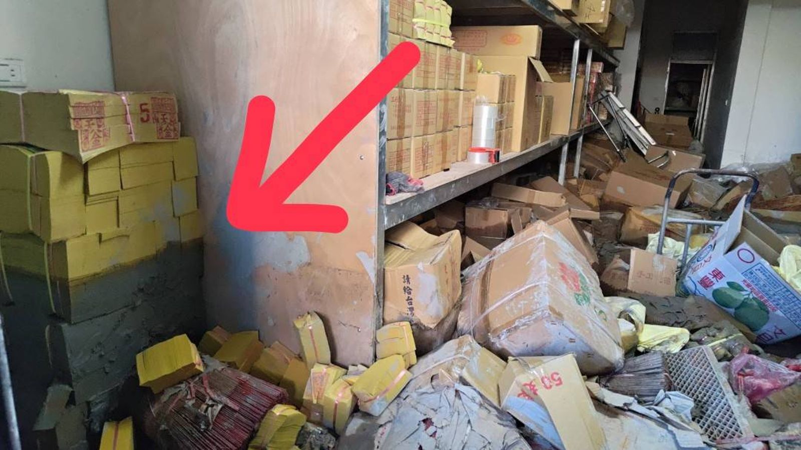 曾先生指著牆邊已變成黑色的金紙說，泥水就是淹到這麼高！王吟芳攝