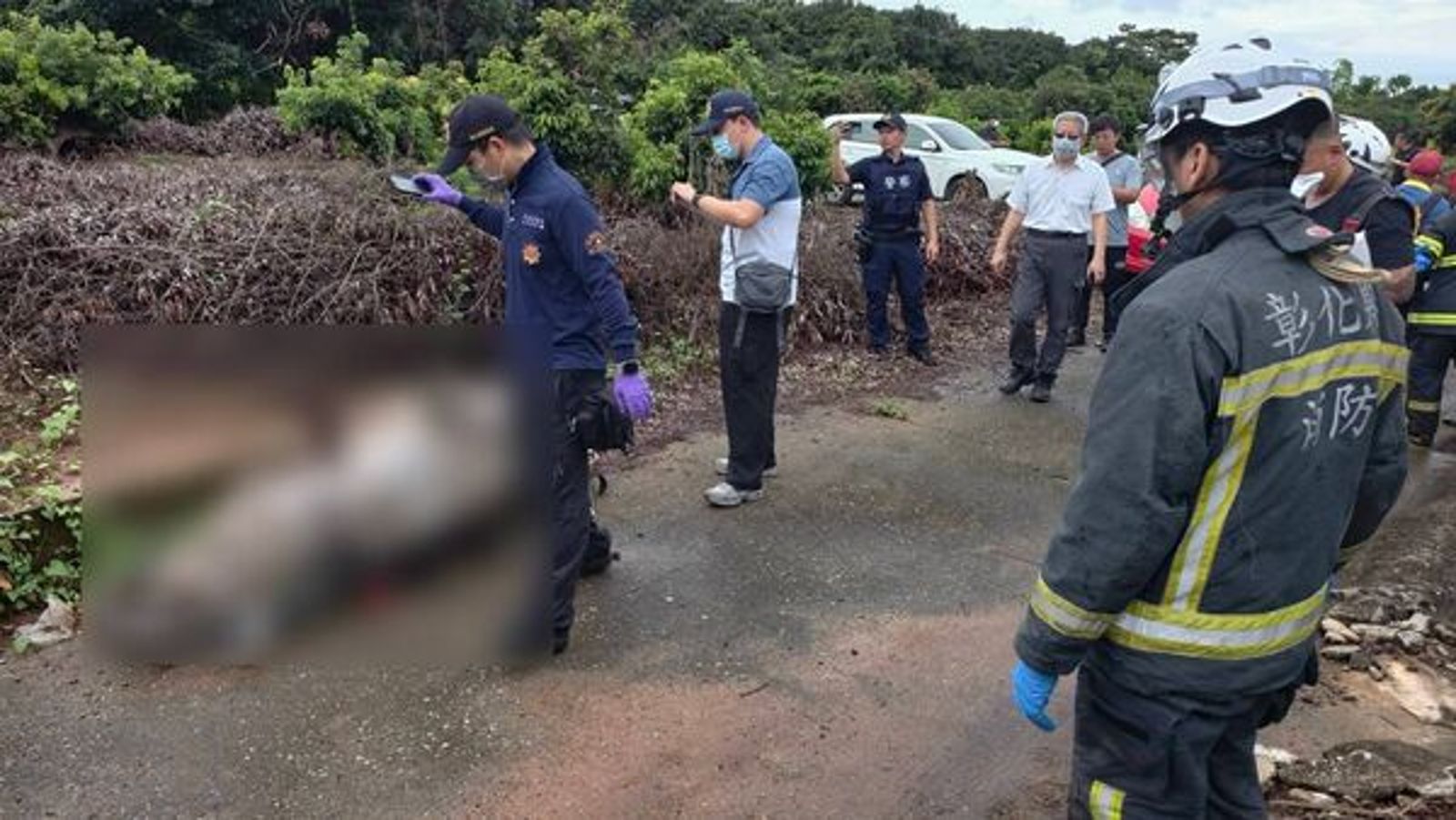 警消將遺體移出荔枝園，交由鑑識小組調查採證。民眾提供