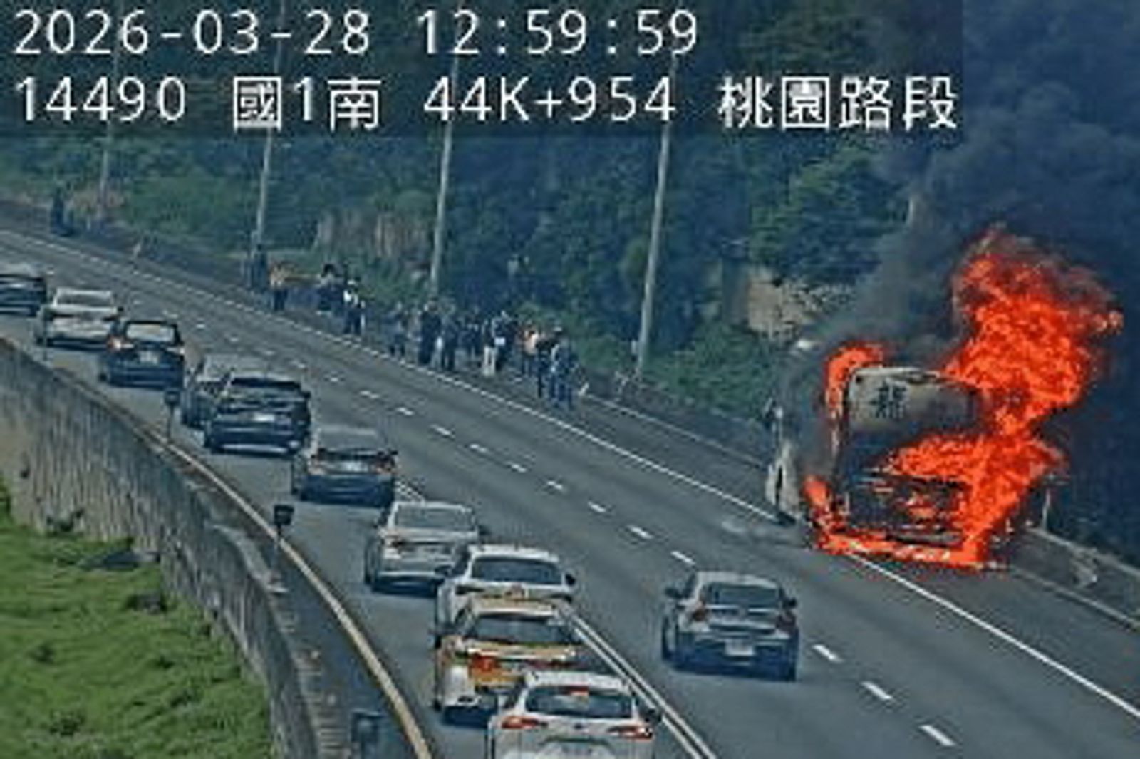 遊覽車停在國道路肩,整輛車陷入火海。翻攝國道即時路況監視器