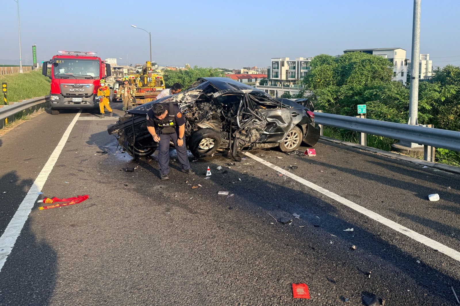 黑色轎車疑似自撞護欄,駕駛被拋出車外送醫不治,事故車輛嚴重解體變形。圖/民眾提供