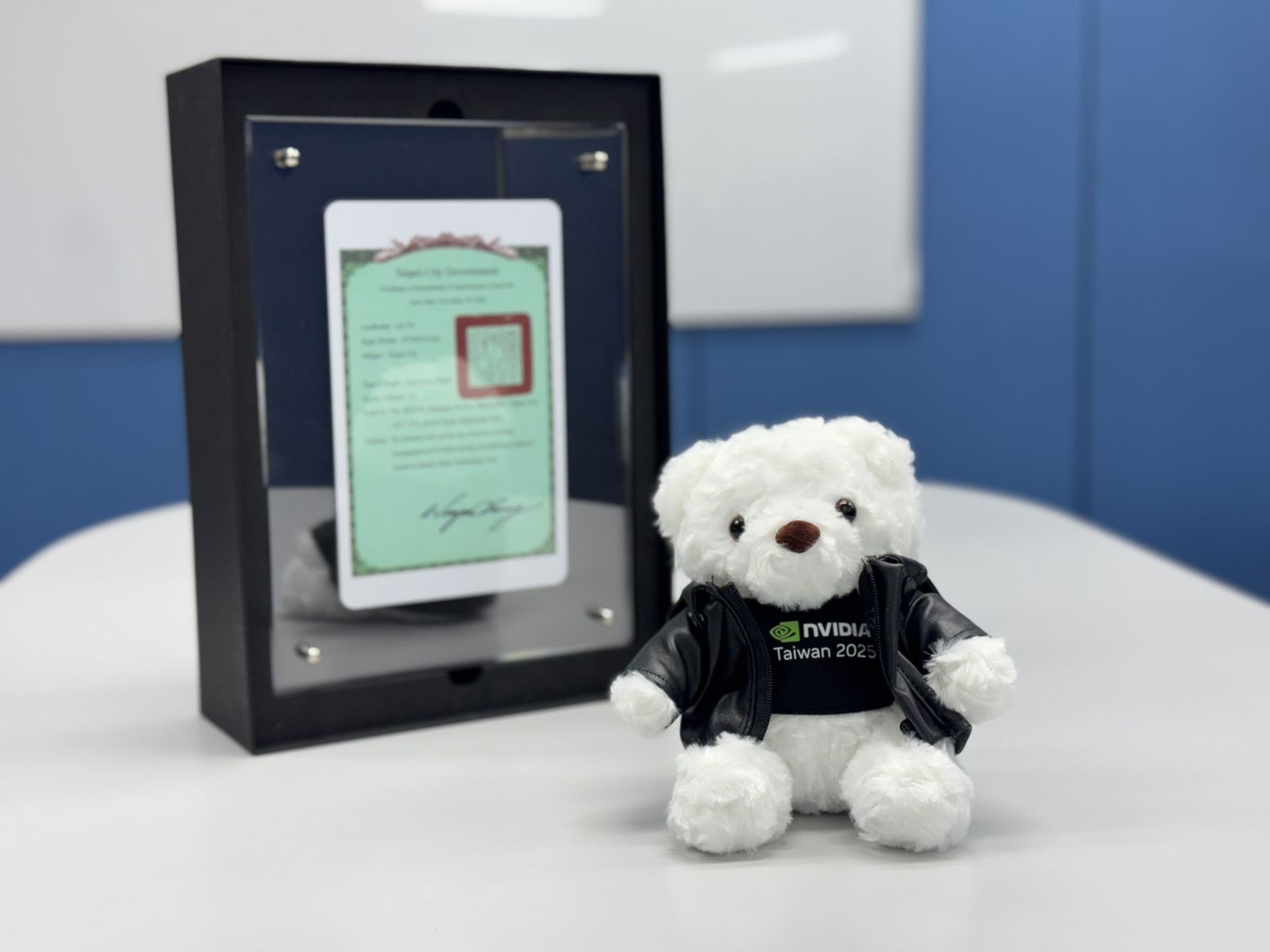 會面尾聲,蔣萬安向Ekman副總裁一行致贈特製的「T17、T18土地權狀造型悠遊卡」,Ekman則回贈輝達吉祥物皮衣白熊玩偶。(圖/台北市政府提供)