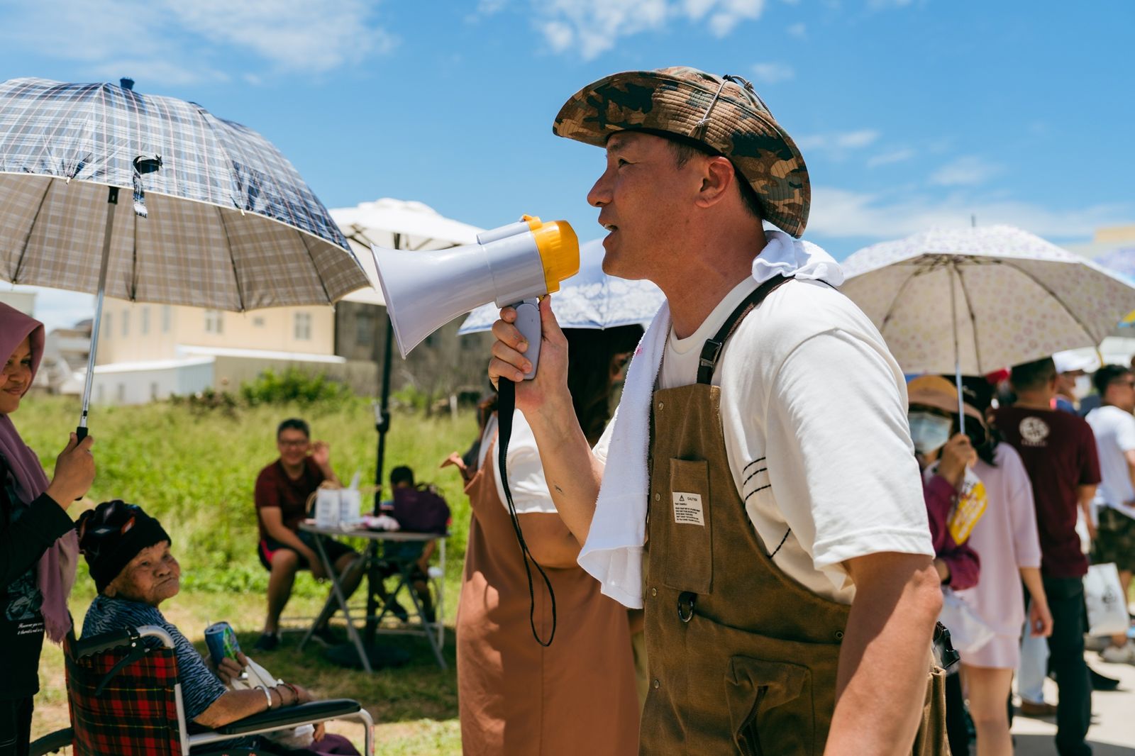 《歐吉桑騎士》李銘忠向排隊居民致意請再稍等。公視提供